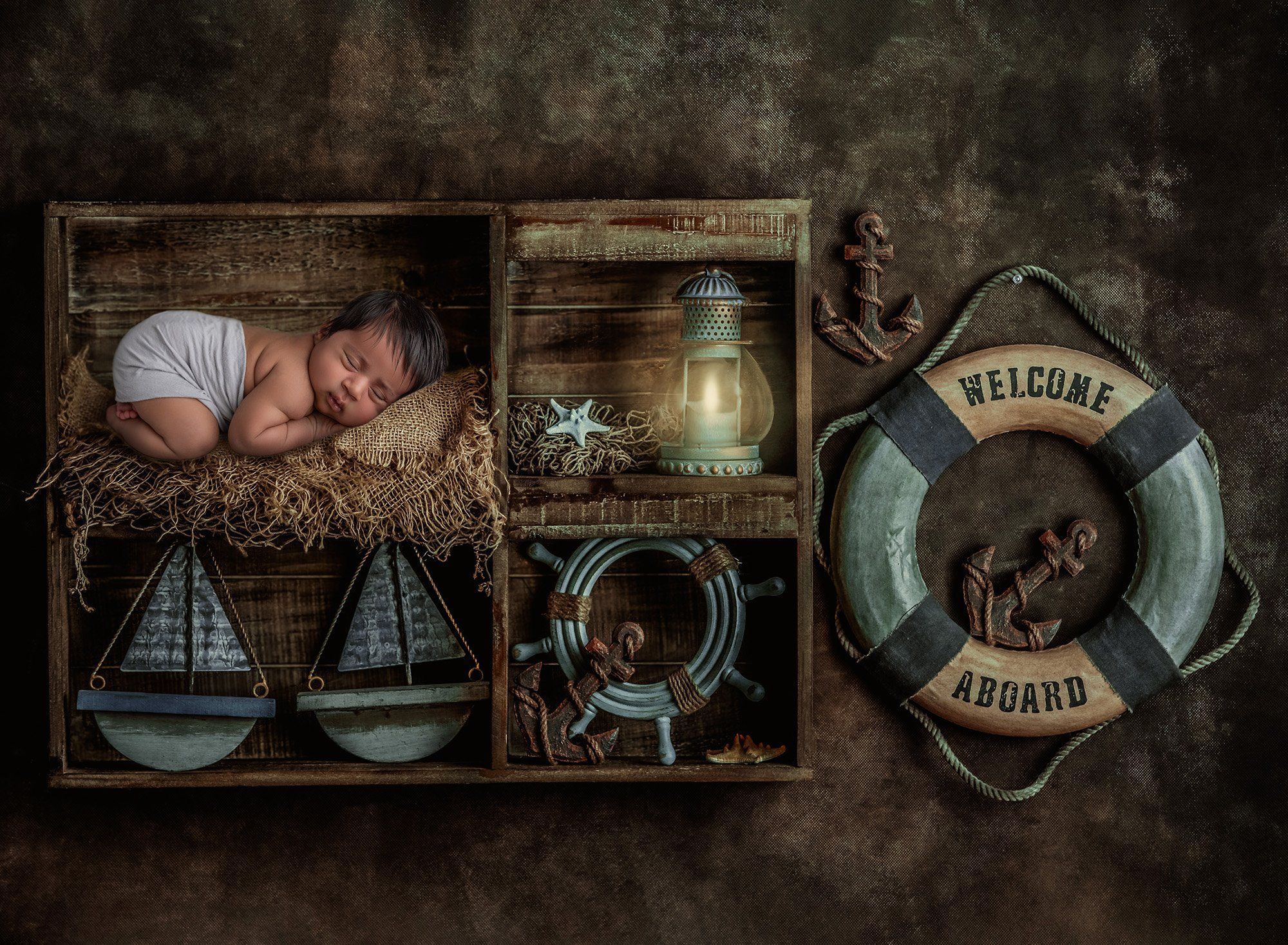 newborn sleeping on straw blanket with a sailor themed background