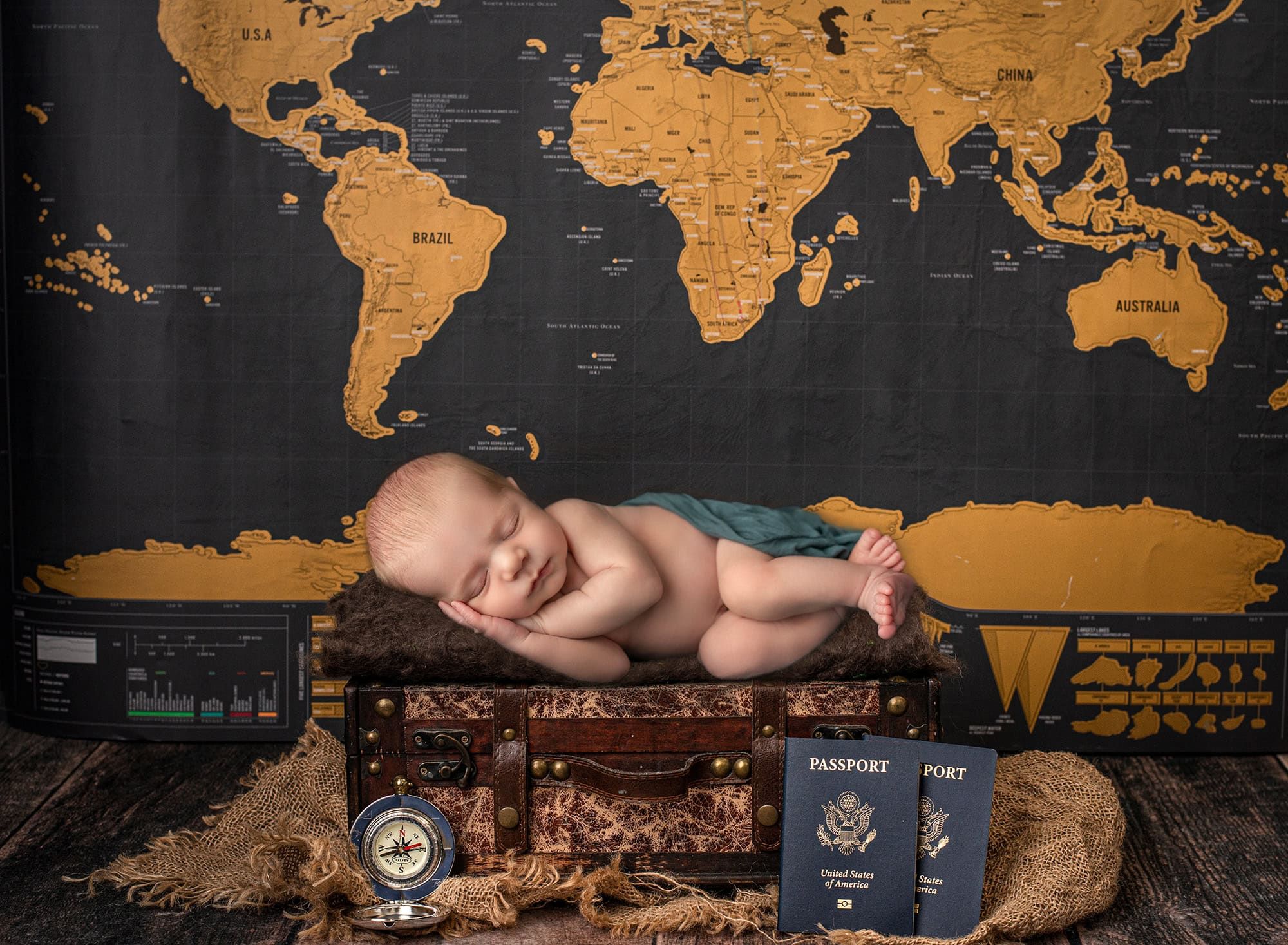 Glastonbury Newborn Photographer newborn baby boy asleep on rustic trunk surrounded by world map and transports