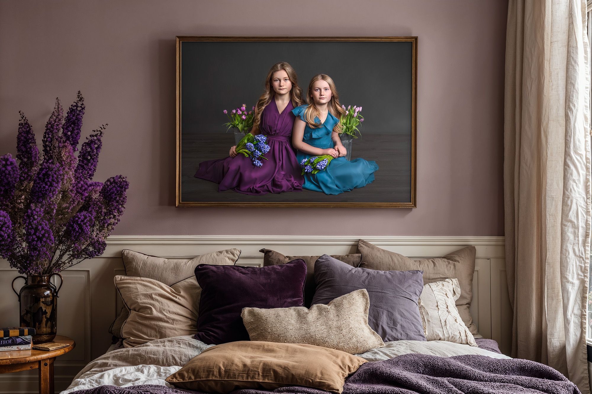 hand-painted canvas portrait framed and on the wall of two young girls holding blue and purple flowers
