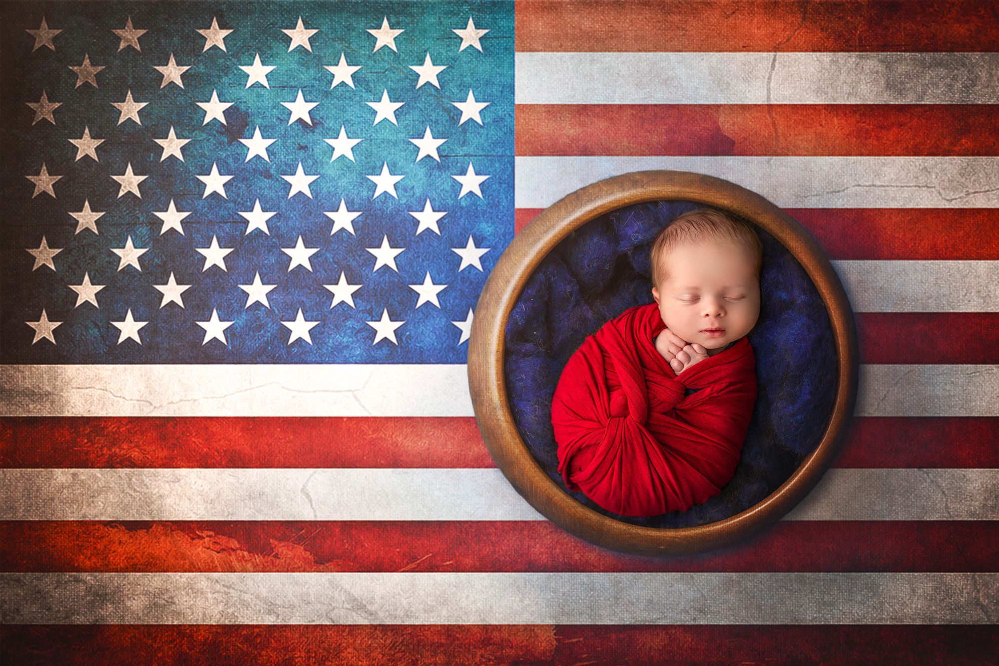 Unique Newborn Photography with Parents Newborn baby wrapped in red asleep in a bowl against a United States of America background.
