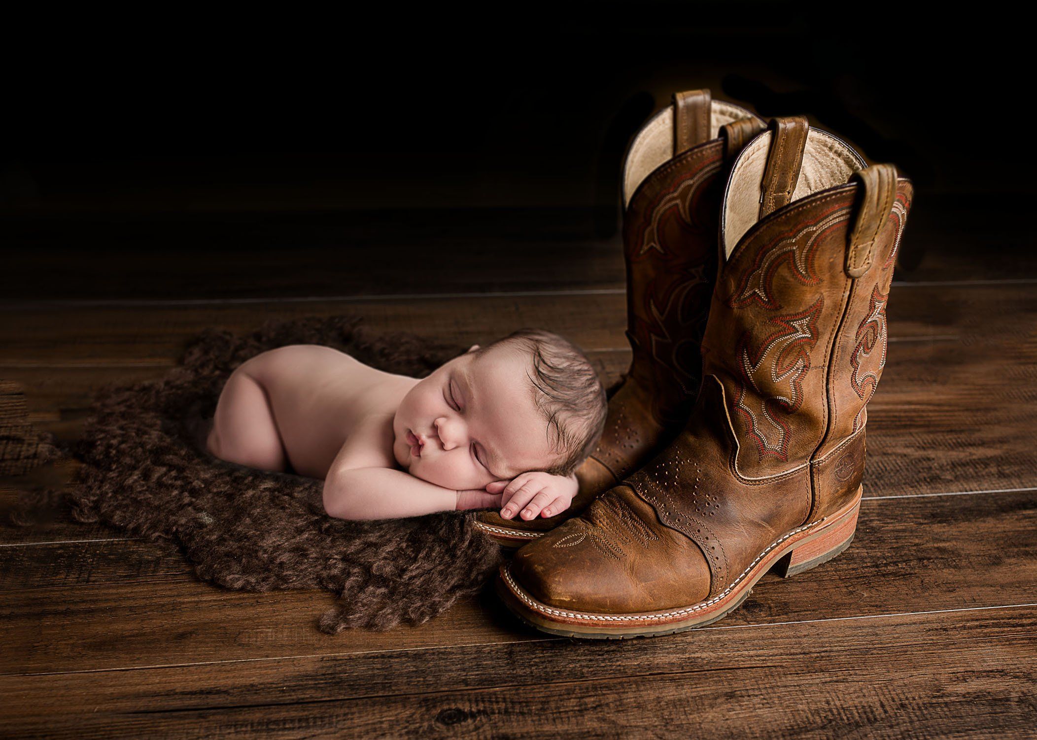 Newborn baby sleeping with head and hands on cowboy boots One Big Happy Photo Amber Sehrt Newborn baby sleeping with head and hands on cowboy boots One Big Happy Photo Amber Sehrt