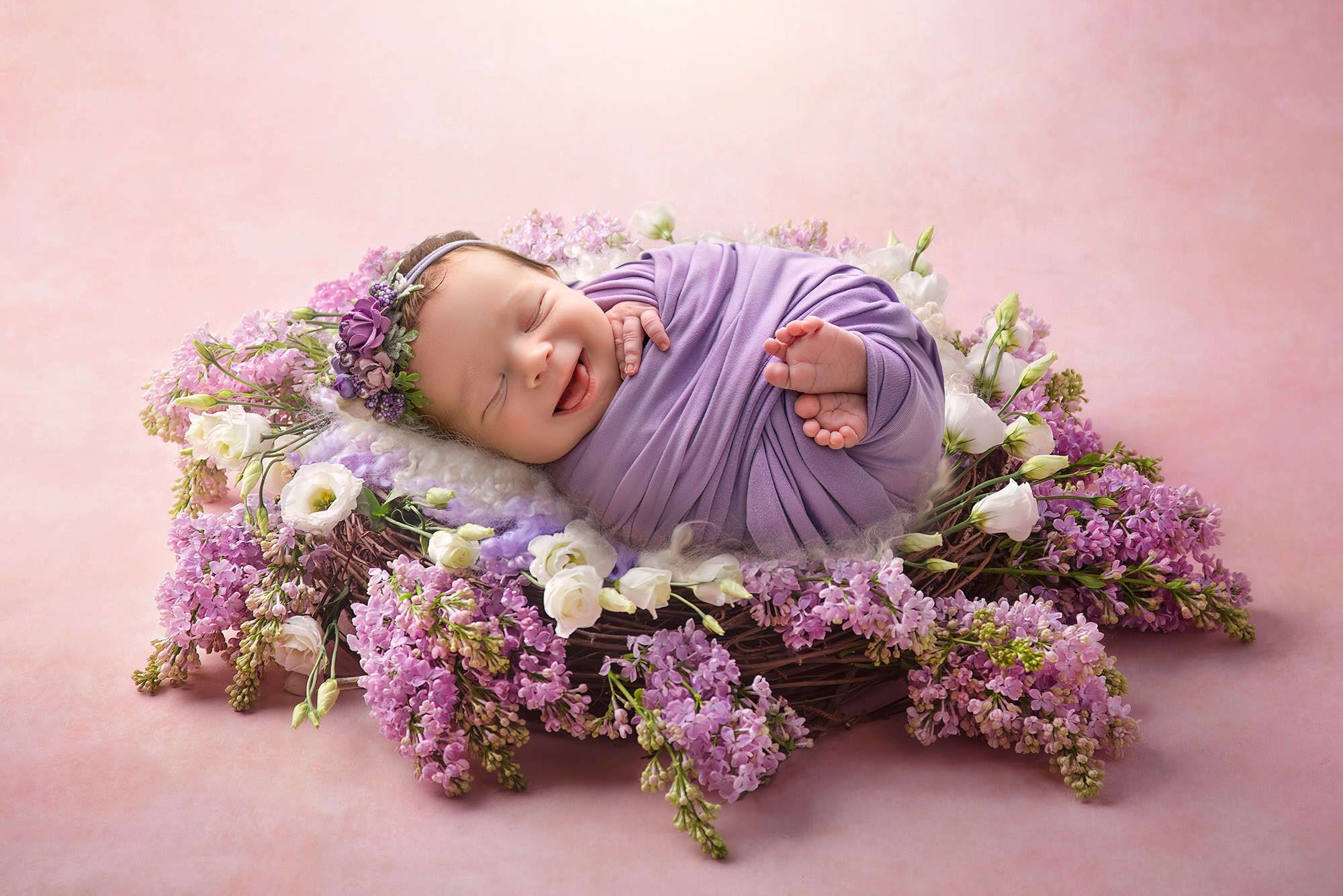 CT newborn photographer baby smiling in a nest of lilacs