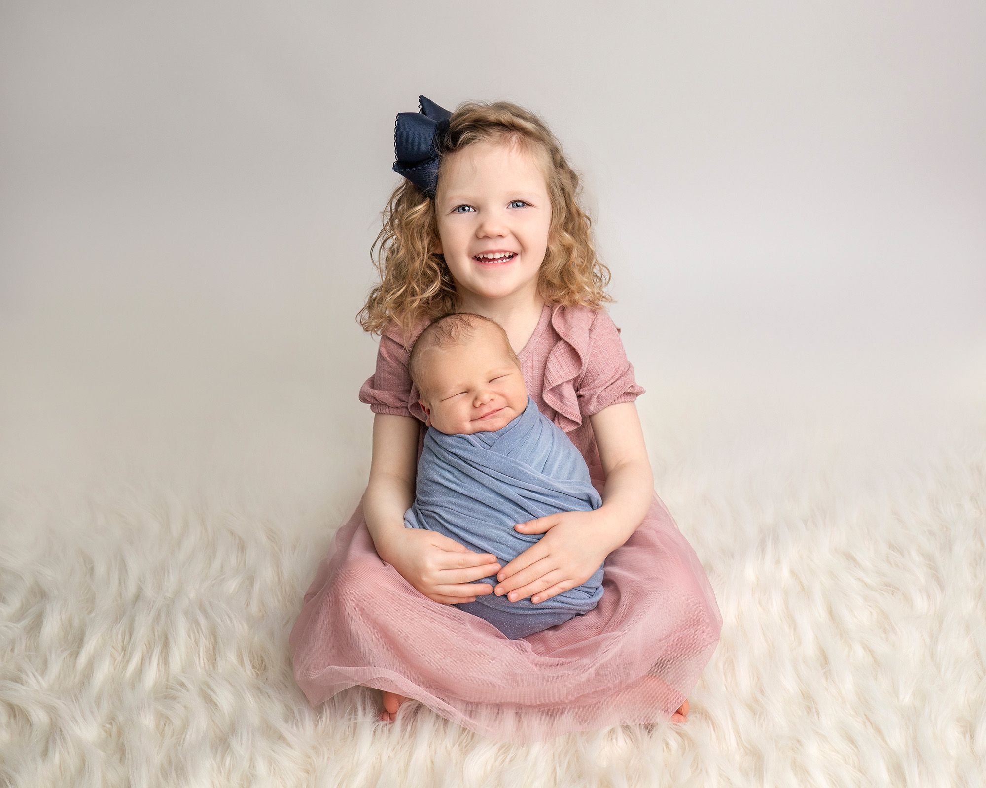 Sibling portrait with big sister holding newborn brother at Glastonbury CT photography studio.