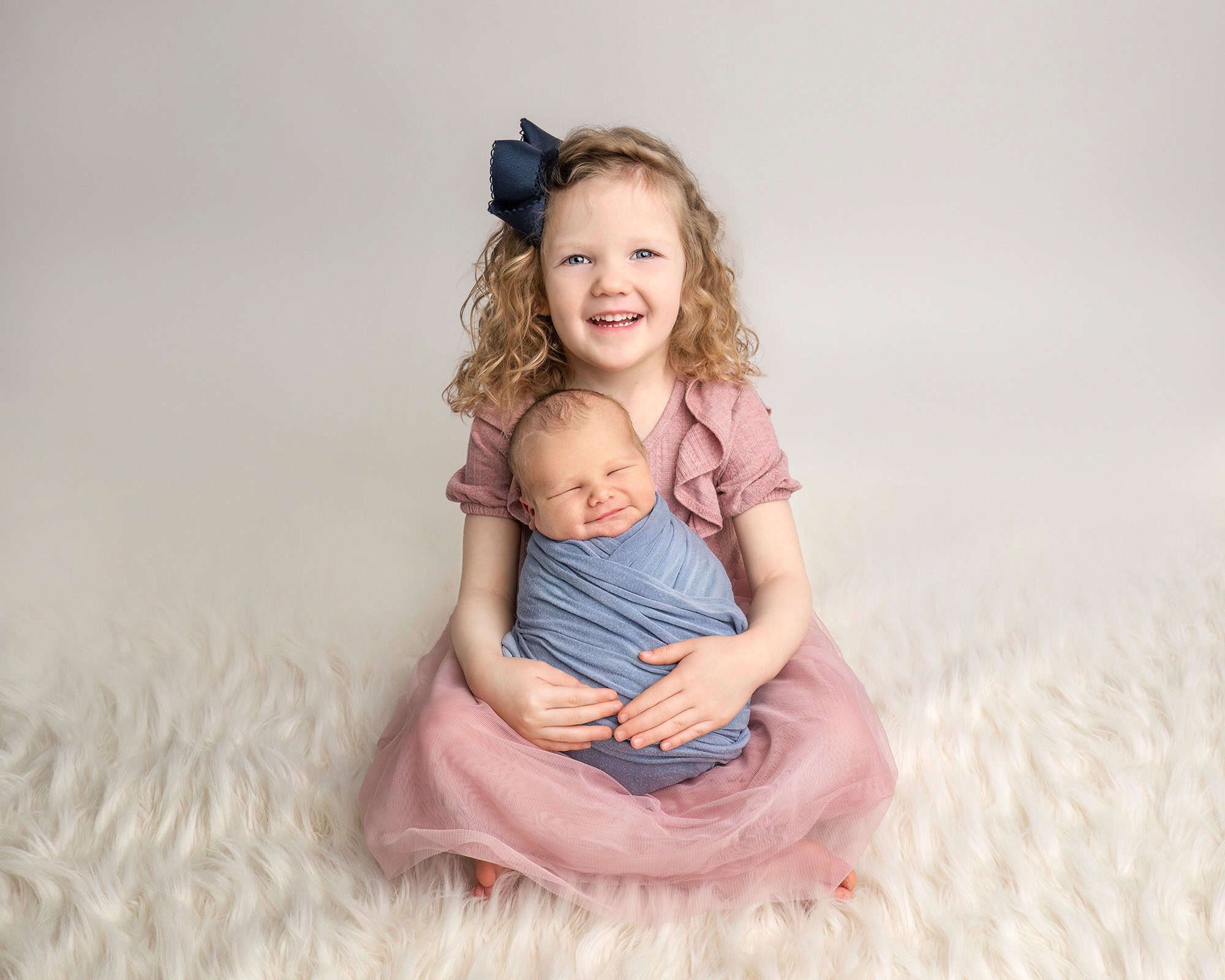 CT newborn photographer Sibling portrait with big sister holding newborn brother at Glastonbury CT photography studio.
