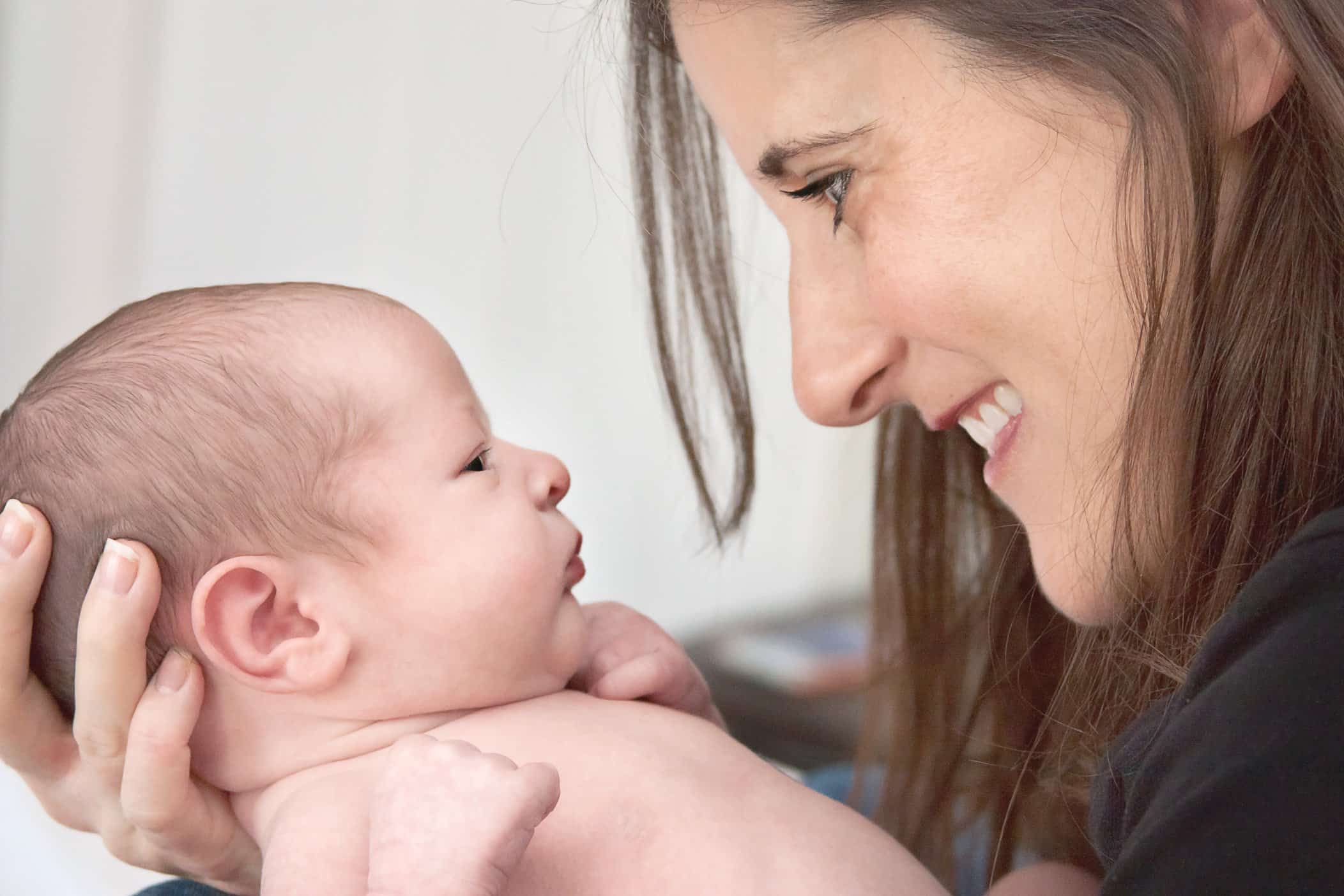 Mom and Newborn son looking into each other's eyes