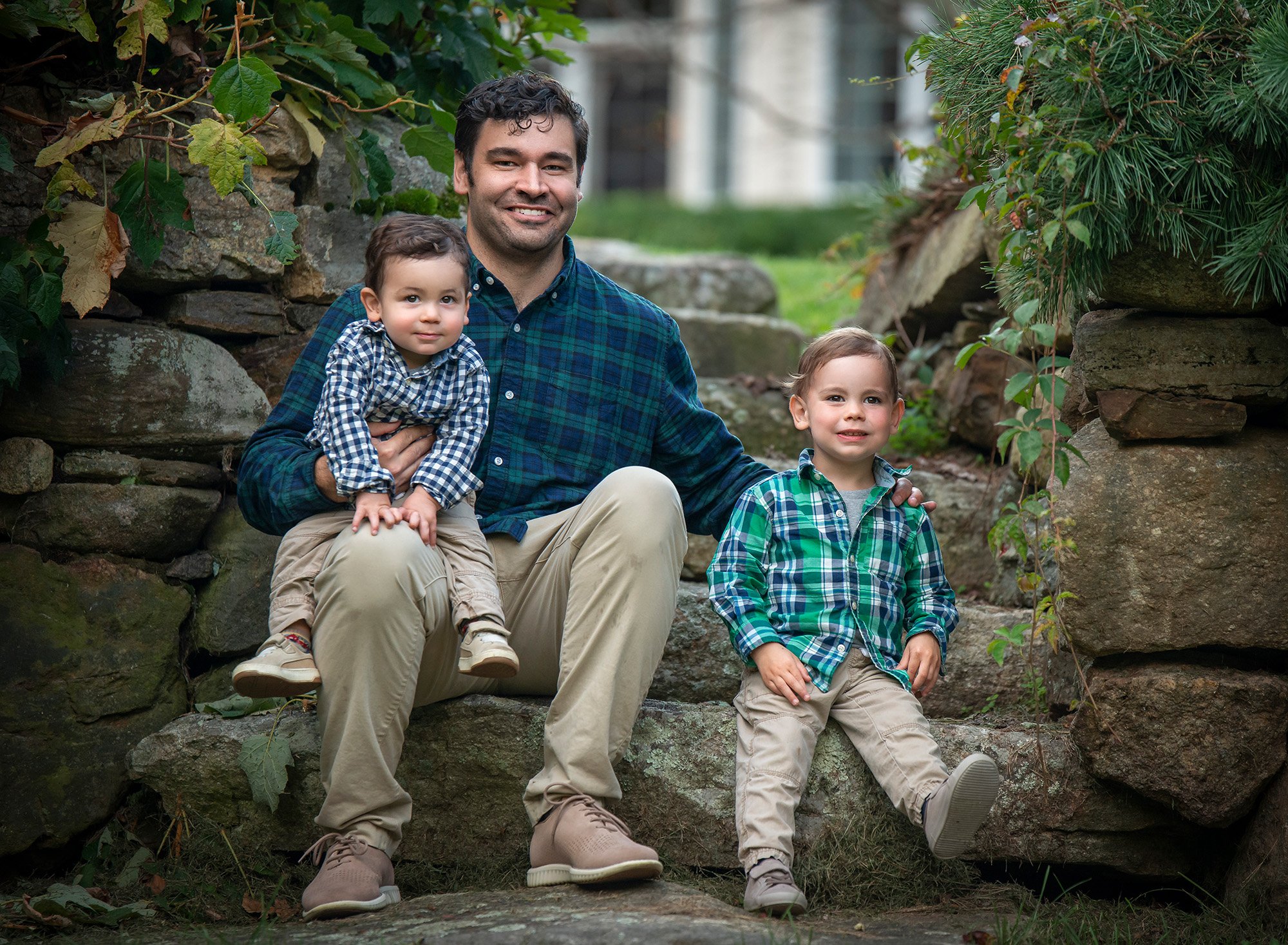 dad sitting on stone steps with his two young sons