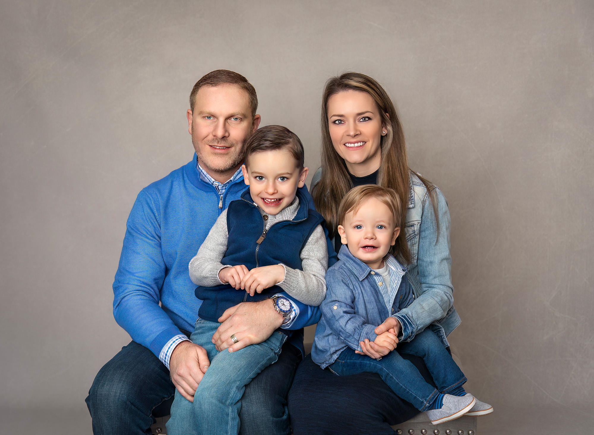 Family portrait of Bryce, Greyson, and their parents smiling together