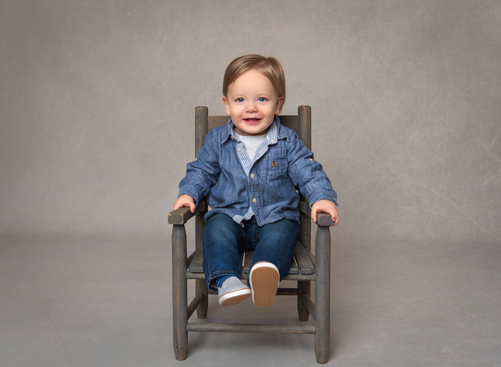 Bryce sitting on a rustic chair, smiling