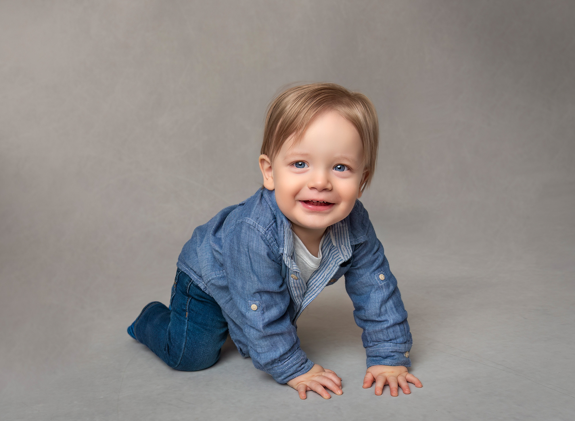 1st Birthday Photoshoot Bryce crawling on the floor with a smile