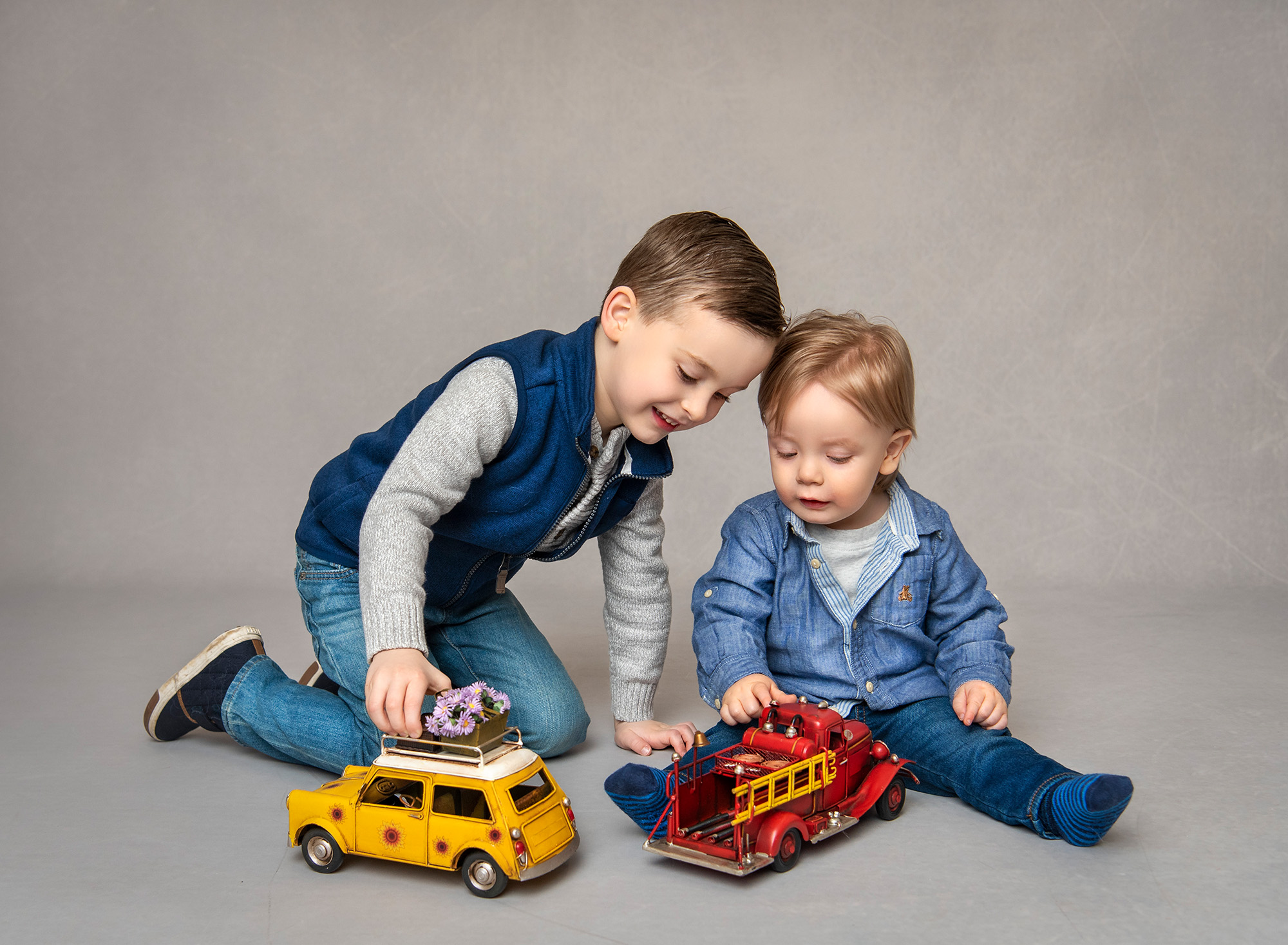 Bryce and Greyson playing with a vintage firetruck and toy car