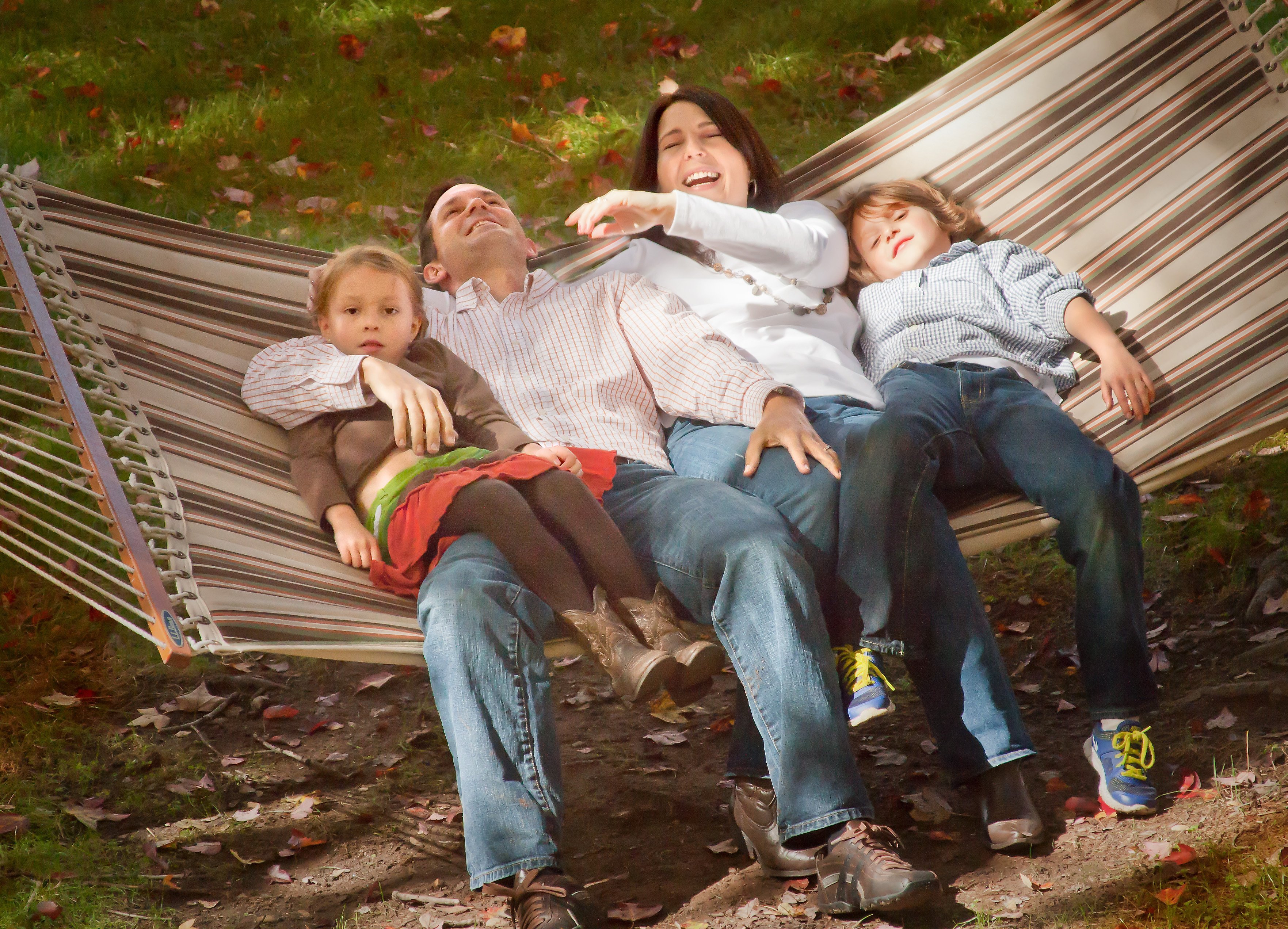 Family of four tries to fit in a hammock laughing