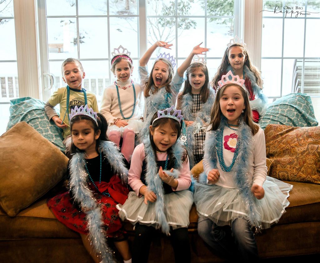 kids sitting on a couch dressed up as princesses posing for a picture