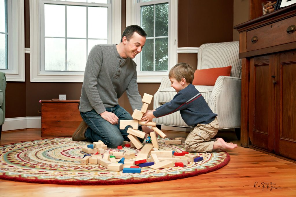 Dad and young son playing with blocks on the floor