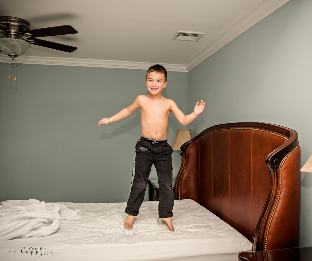 little boy jumping on his parents bed