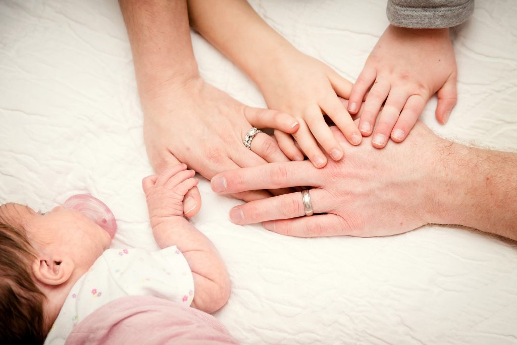 family of 5 hands with newborn 