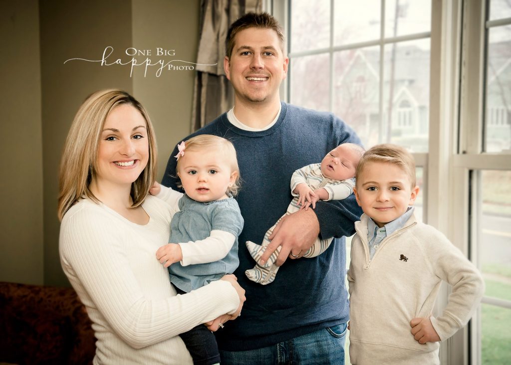 Beecher Family with newborn baby boy posed by a window
