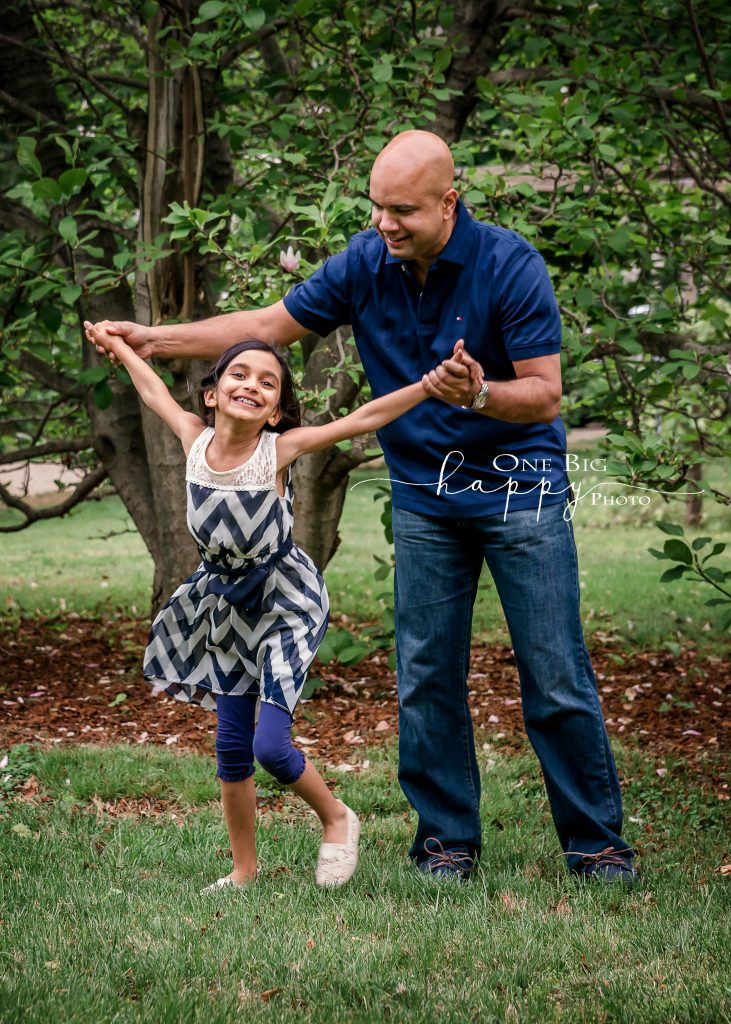 Daddy and daughter dancing in summer garden
