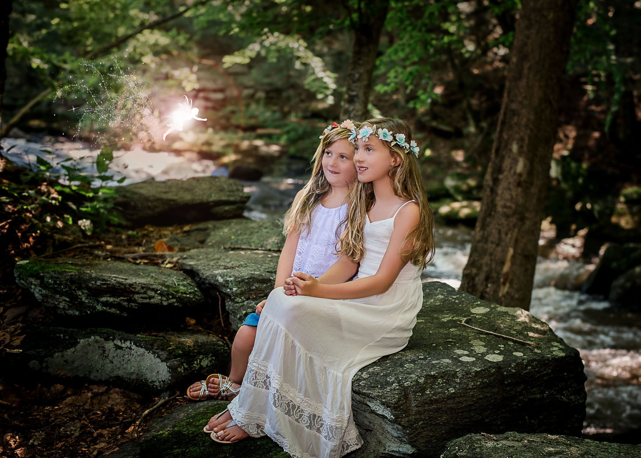 two girls sitting on rock watching fairy fly One Big Happy Photo