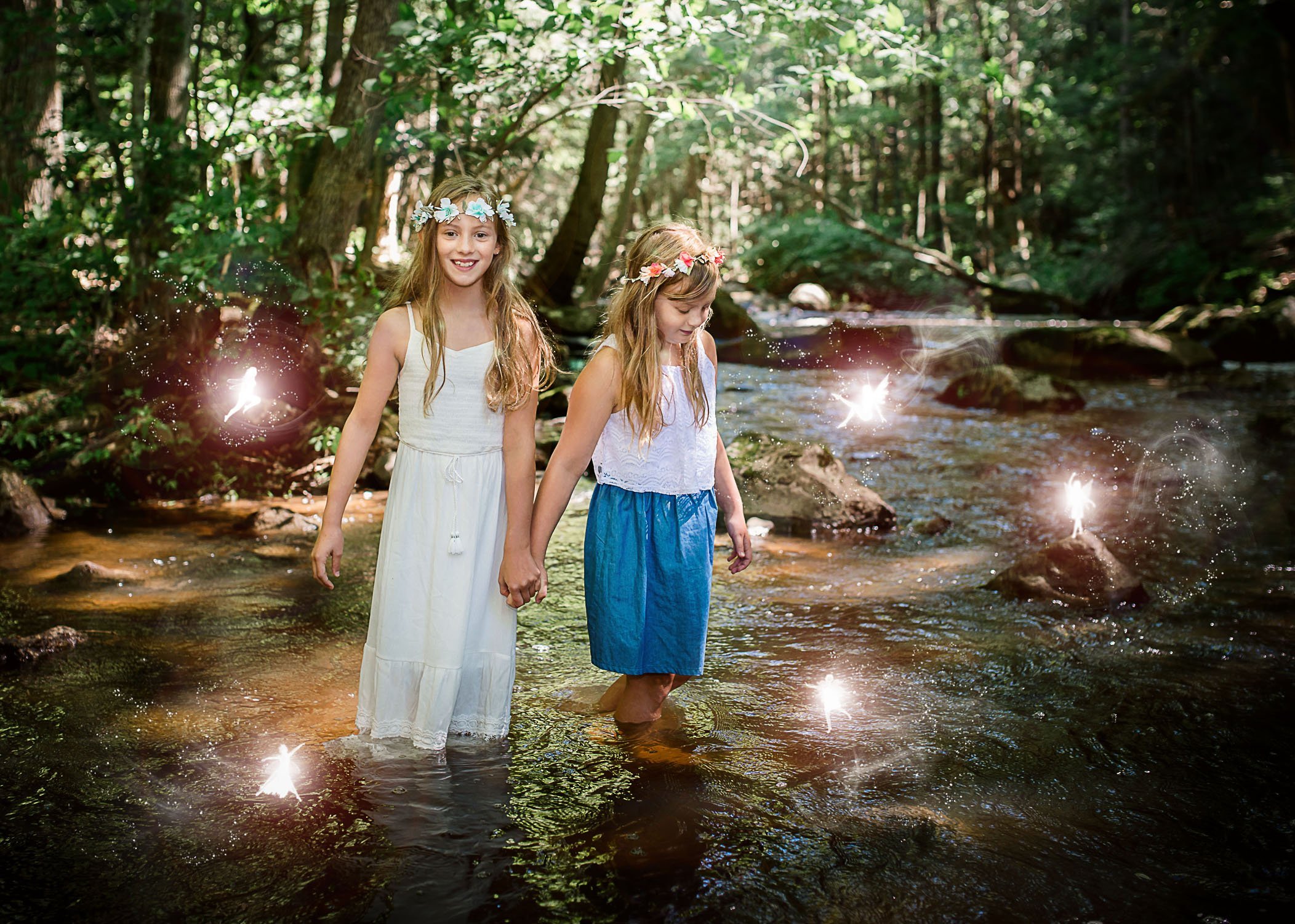 two little girls wading in river with fairies dancing all around One Big Happy Photo
