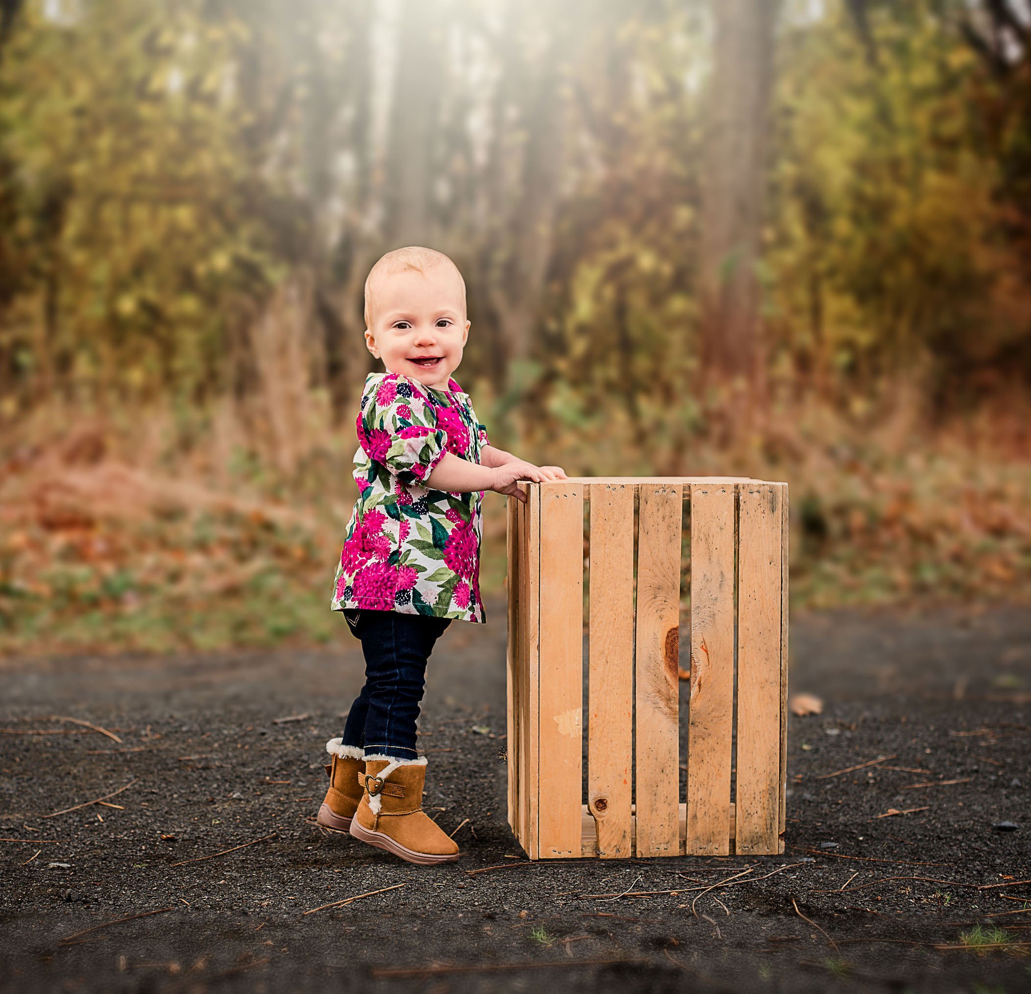 1 year old girl standing near crate outside in fall