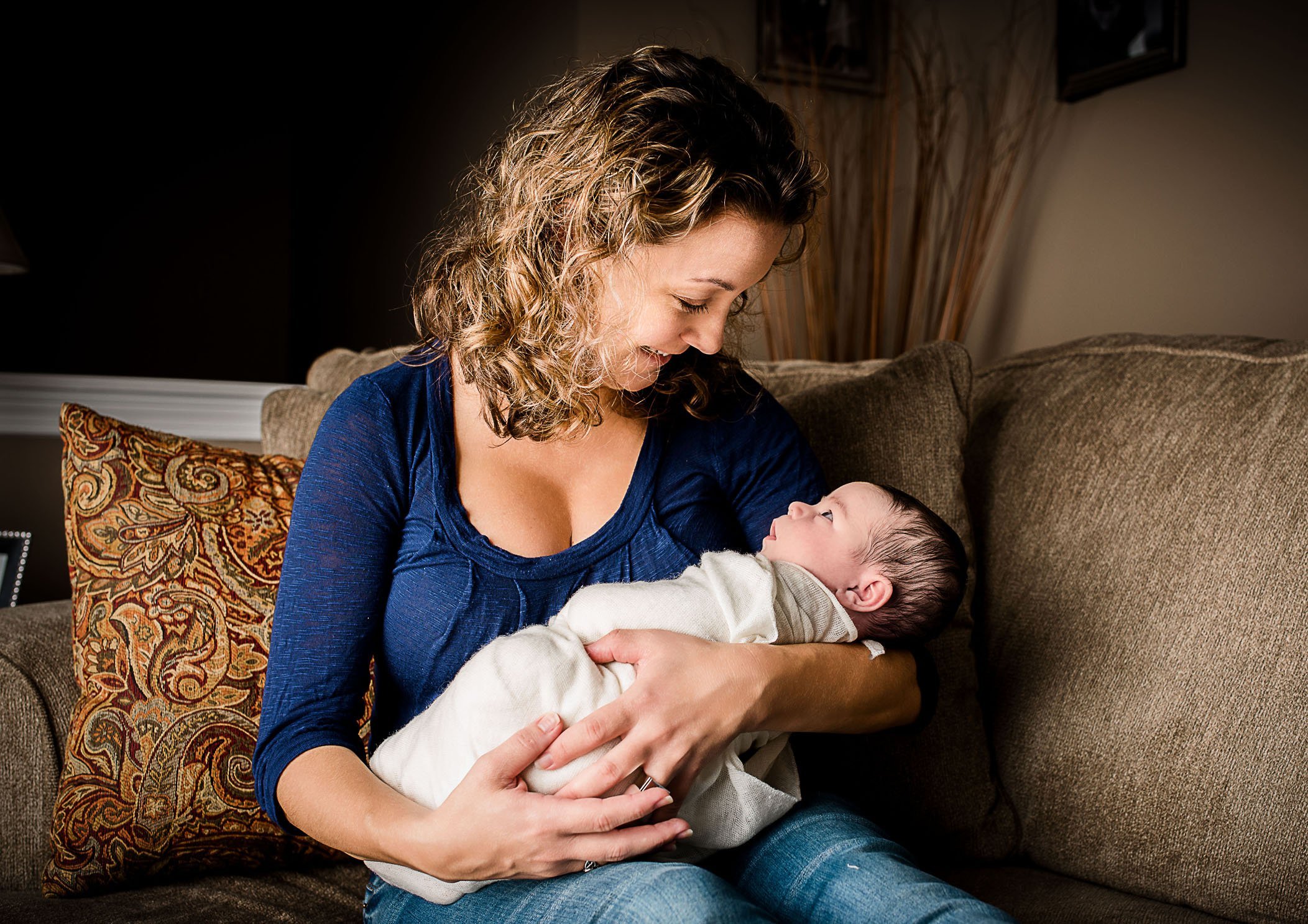 Momma holding newborn baby girl wrapped in her arms smiling One Big Happy Photo Amber Sehrt