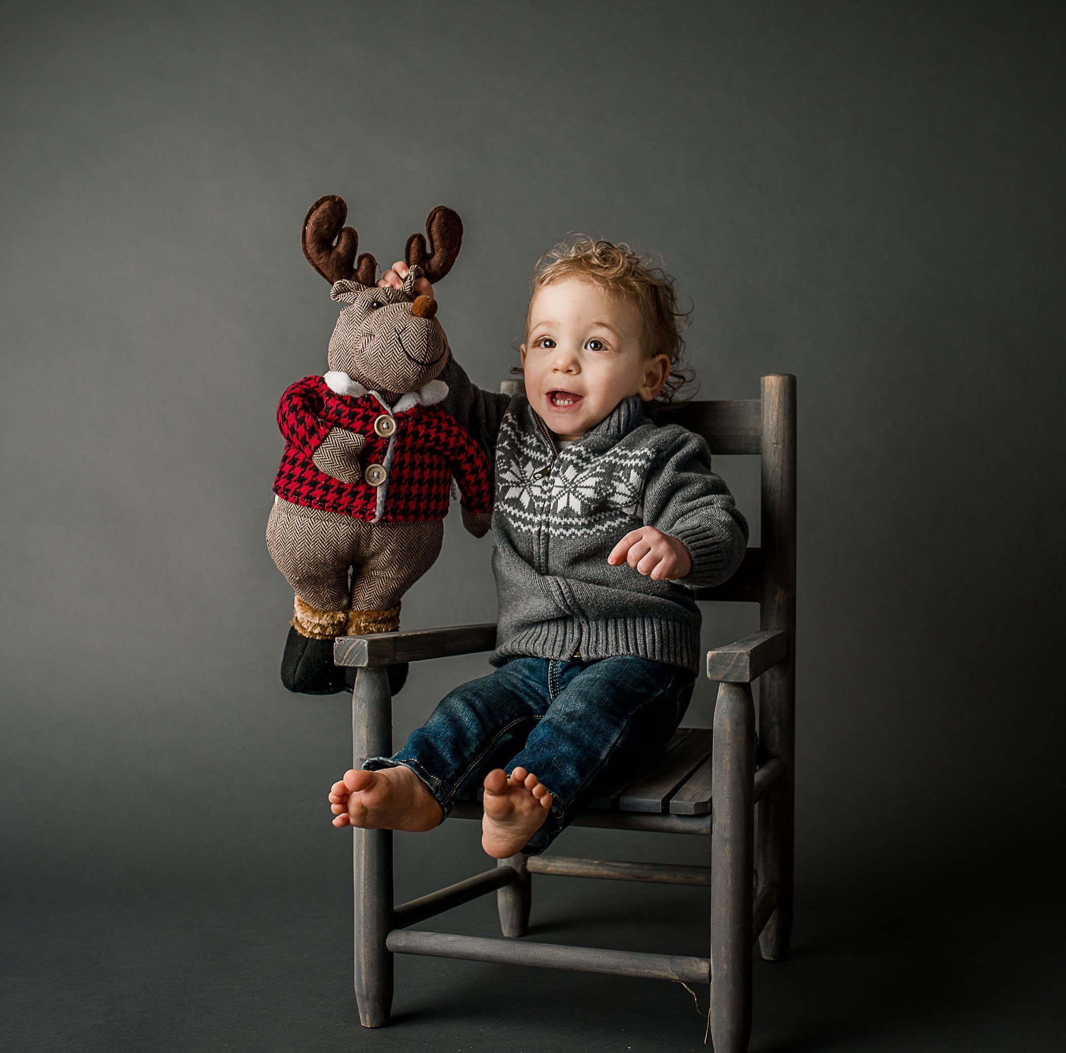 toddler holdling a toy moose by the antlers One Big Happy Photo