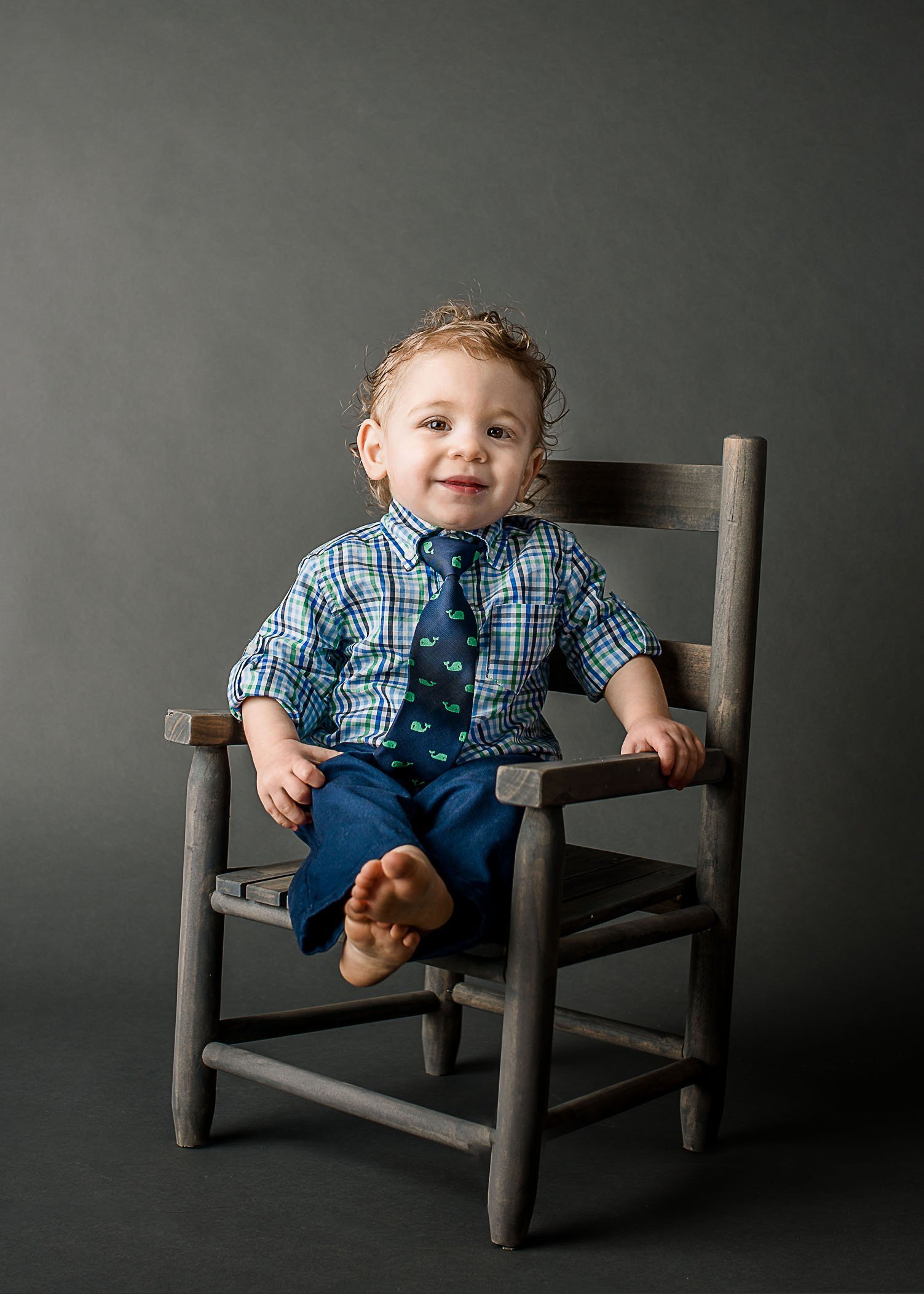 toddler boy sitting in chair wearing a plaid shirt and whale tie One Big Happy Photo