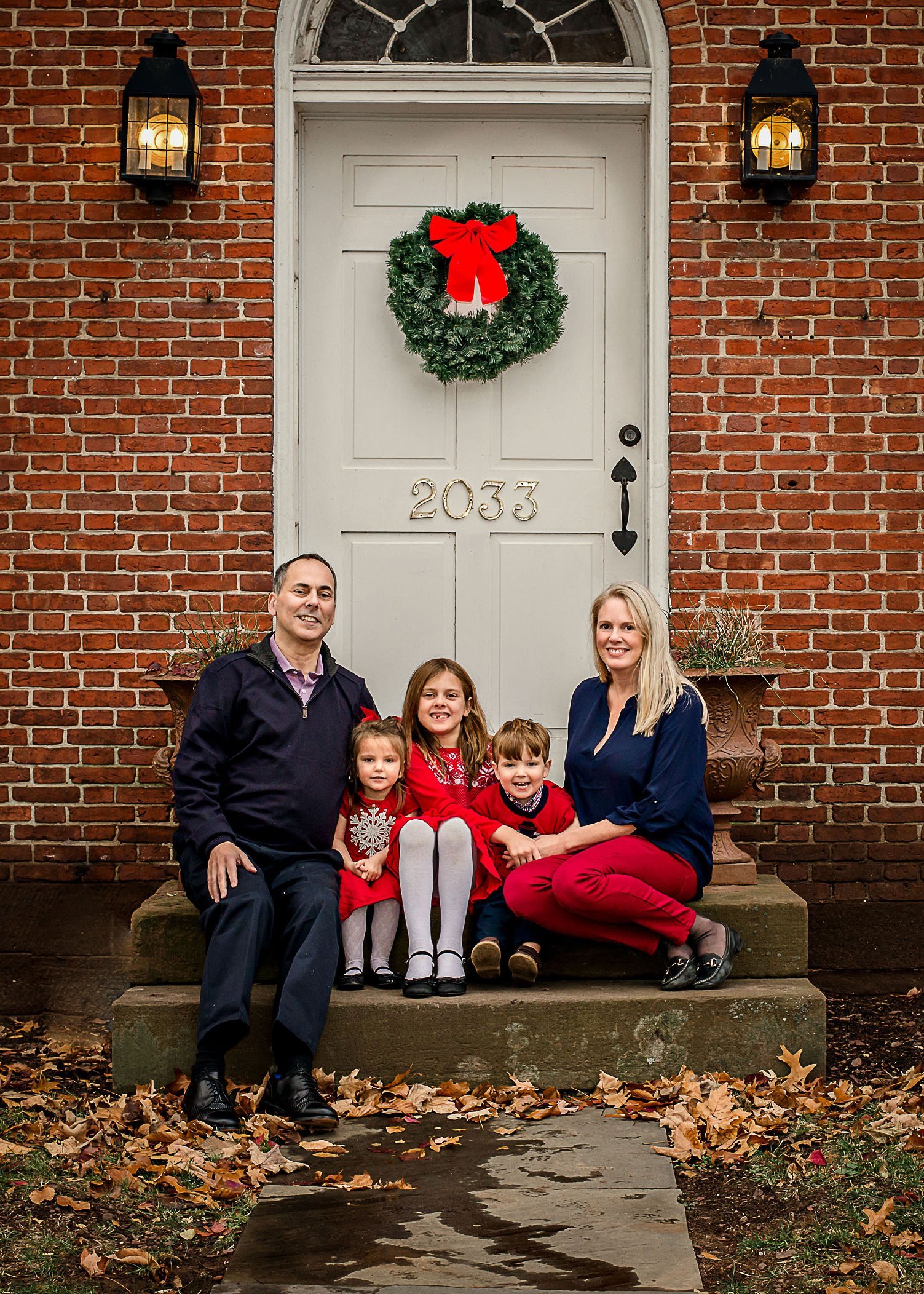 family of 5 posing for a portrait on front stoop