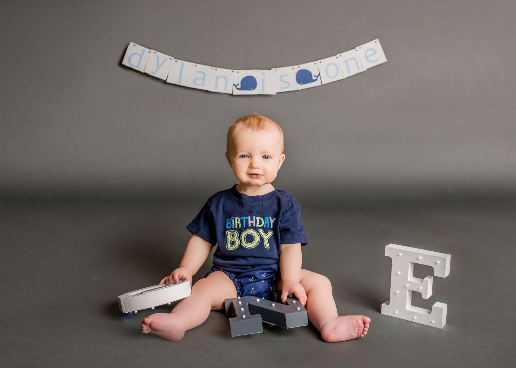 Baby playing with large letters spelling out ONE One Big Happy Photo