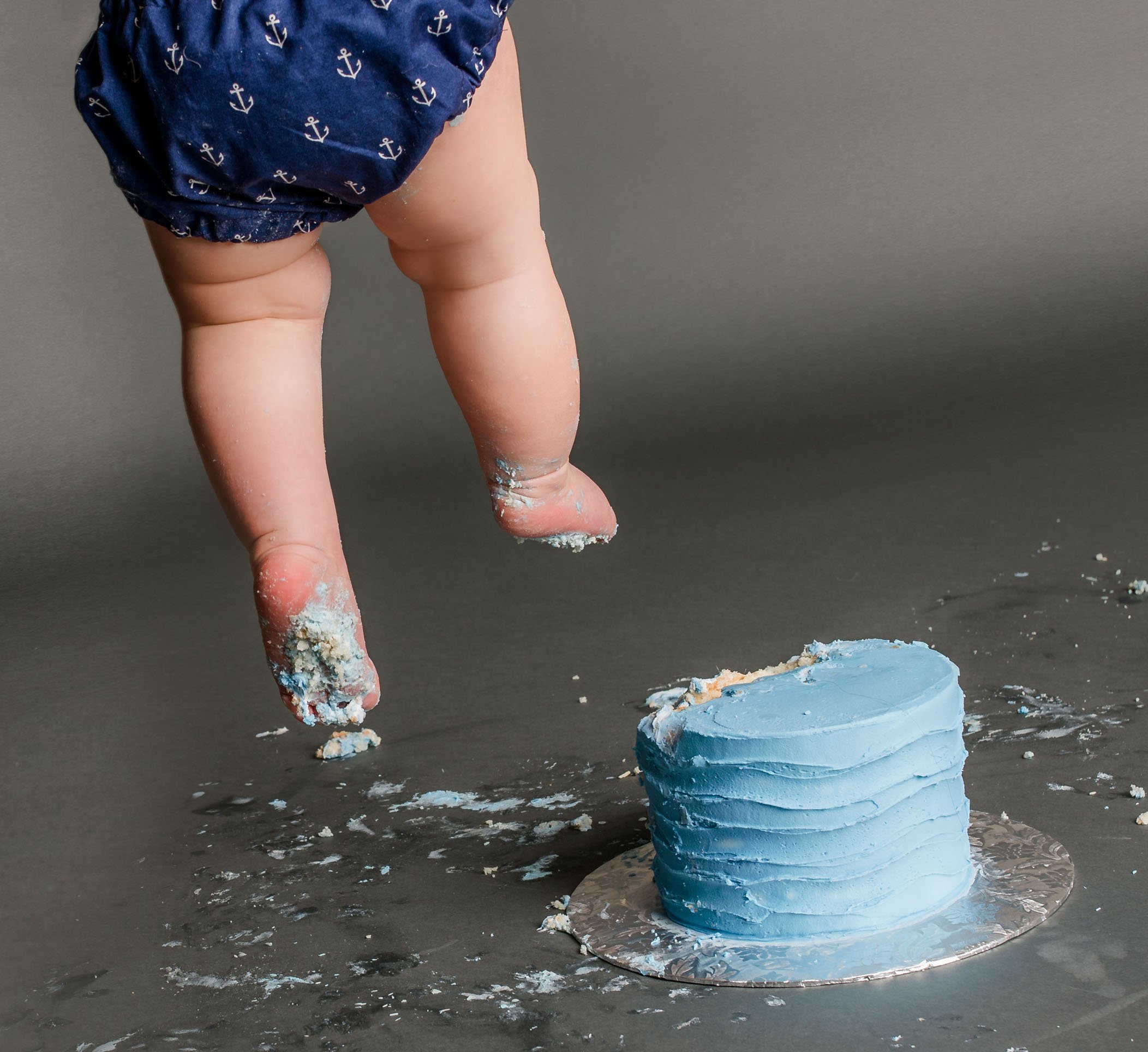 baby legs and feet with cake smashed all over One Big Happy Photo