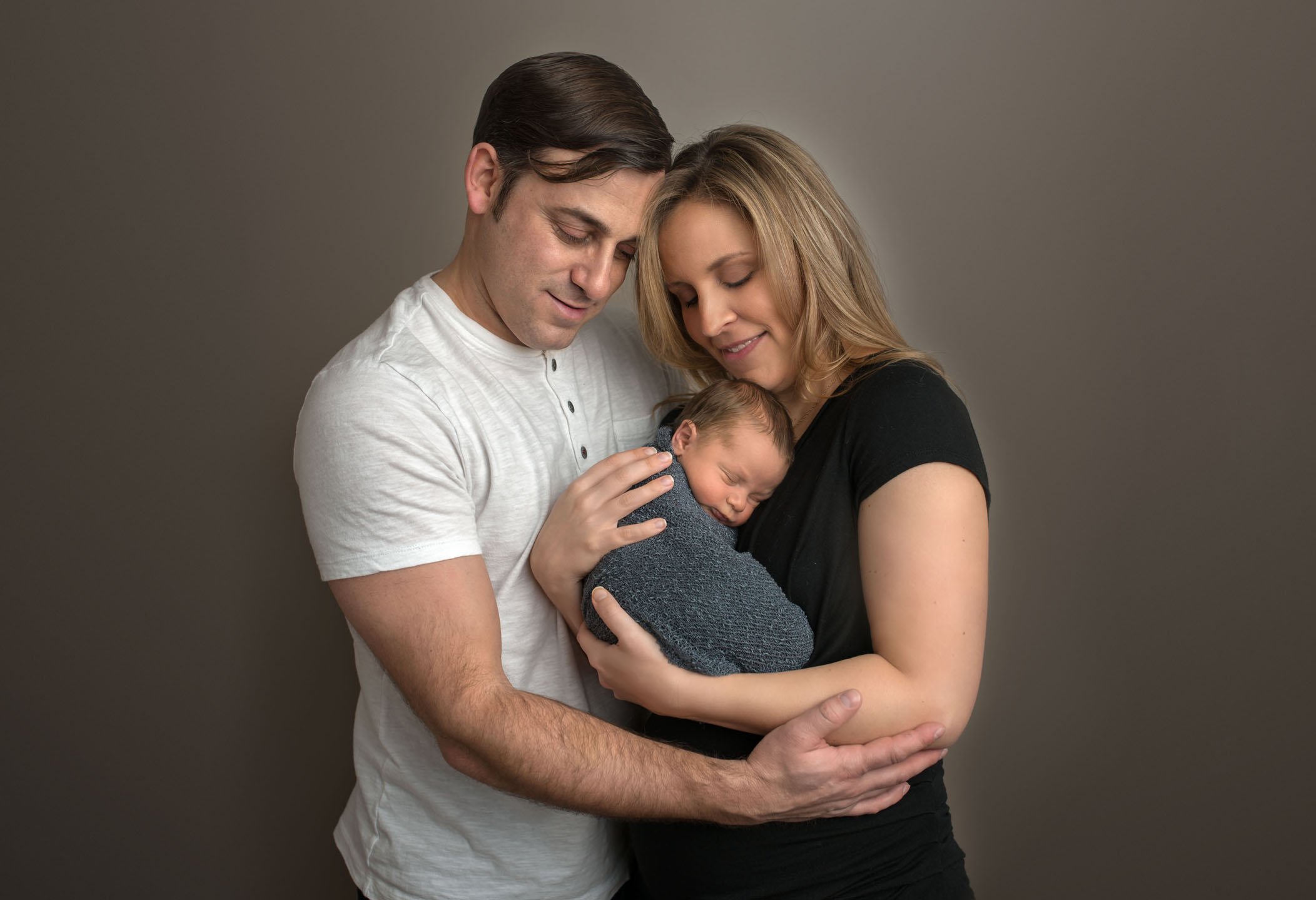 Mom and Dad hold their newborn son in their arms One Big Happy Photo