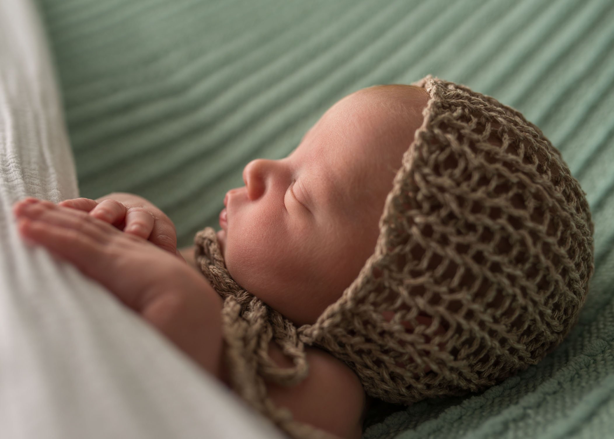 profile of newborn sleeping with fisherman's bonnet One Big Happy Photo