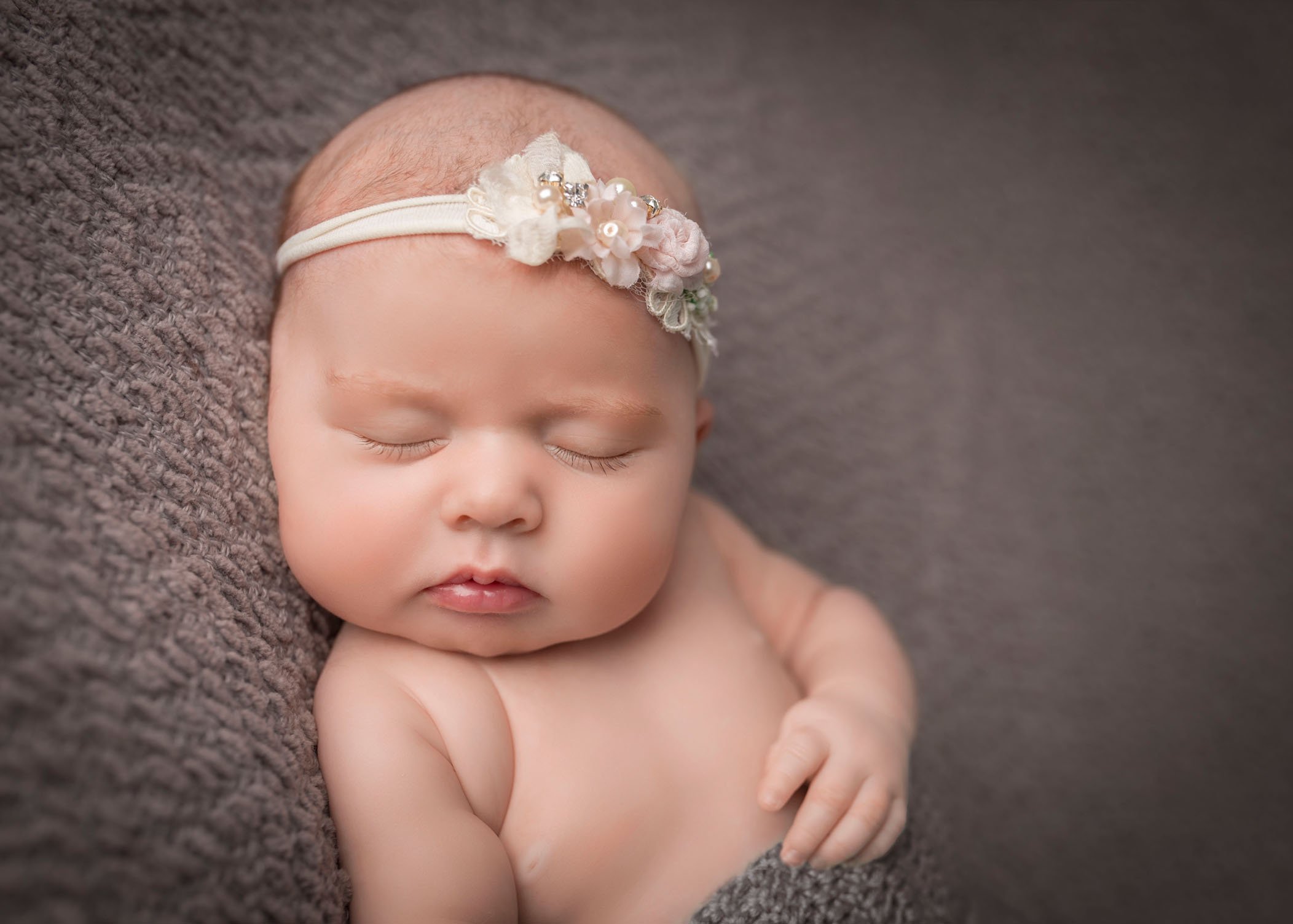 newborn baby girl sleeping with floral headband on