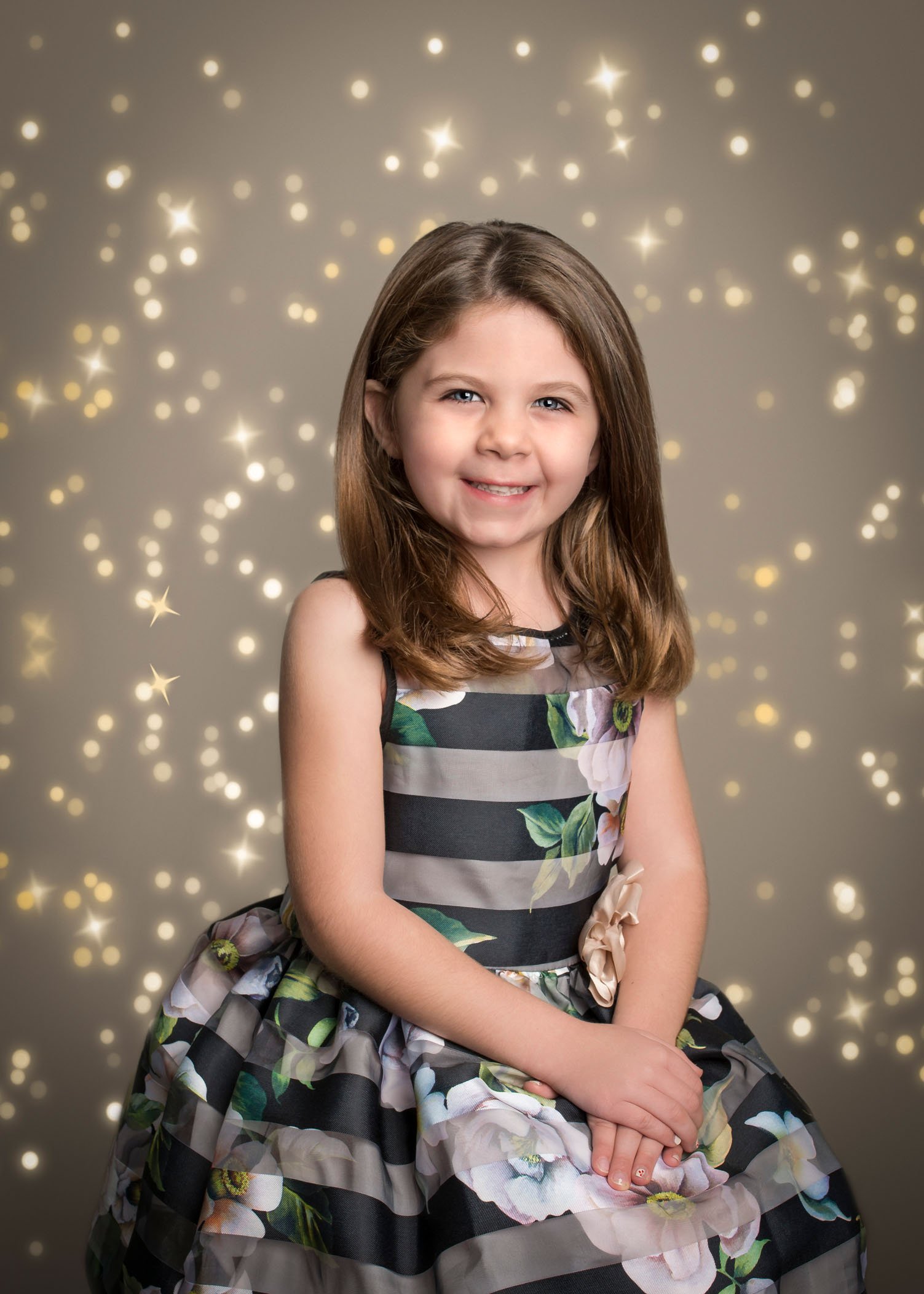 5 year old girl sitting in pretty dress with bokeh lights