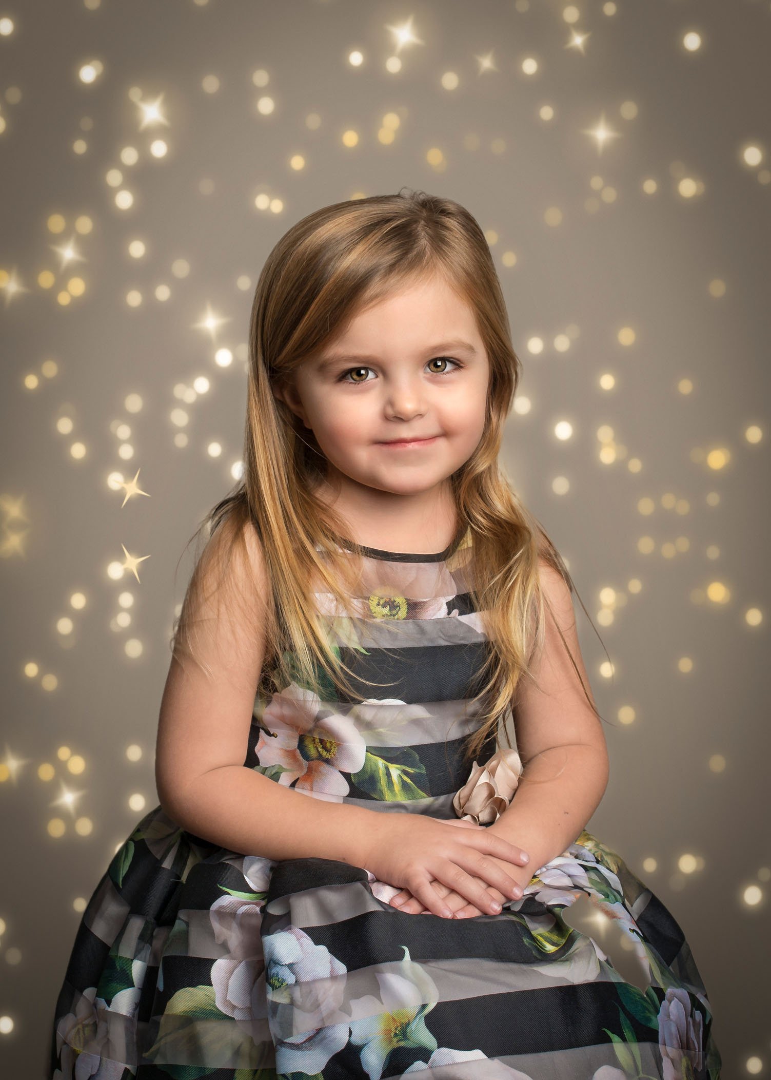 3 year old girl sitting in pretty dress with bokeh lights