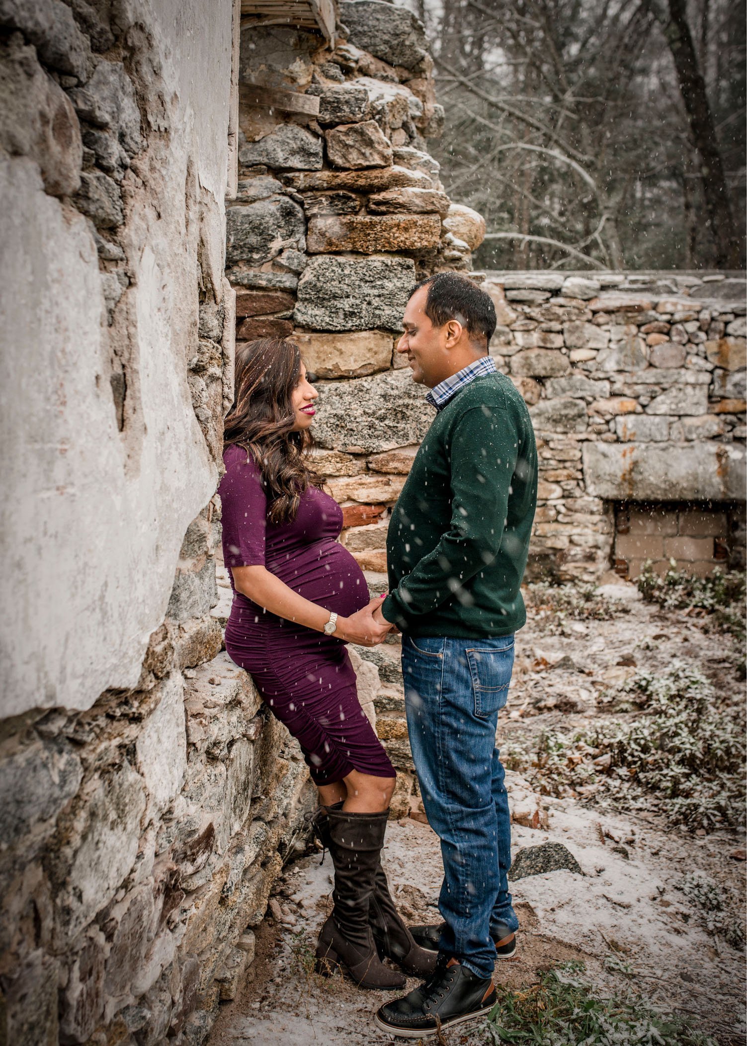 Indian mom and dad to-be outside in building ruins in the snow