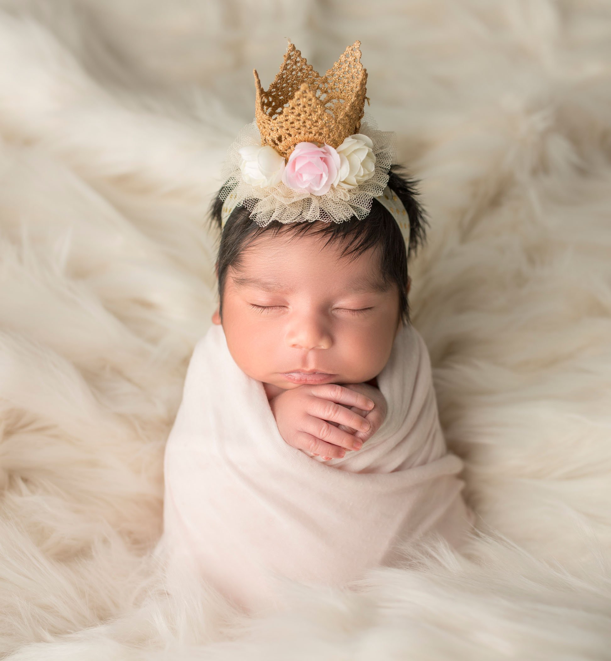 newborn baby girl in potato sack pose with floral crown on her head