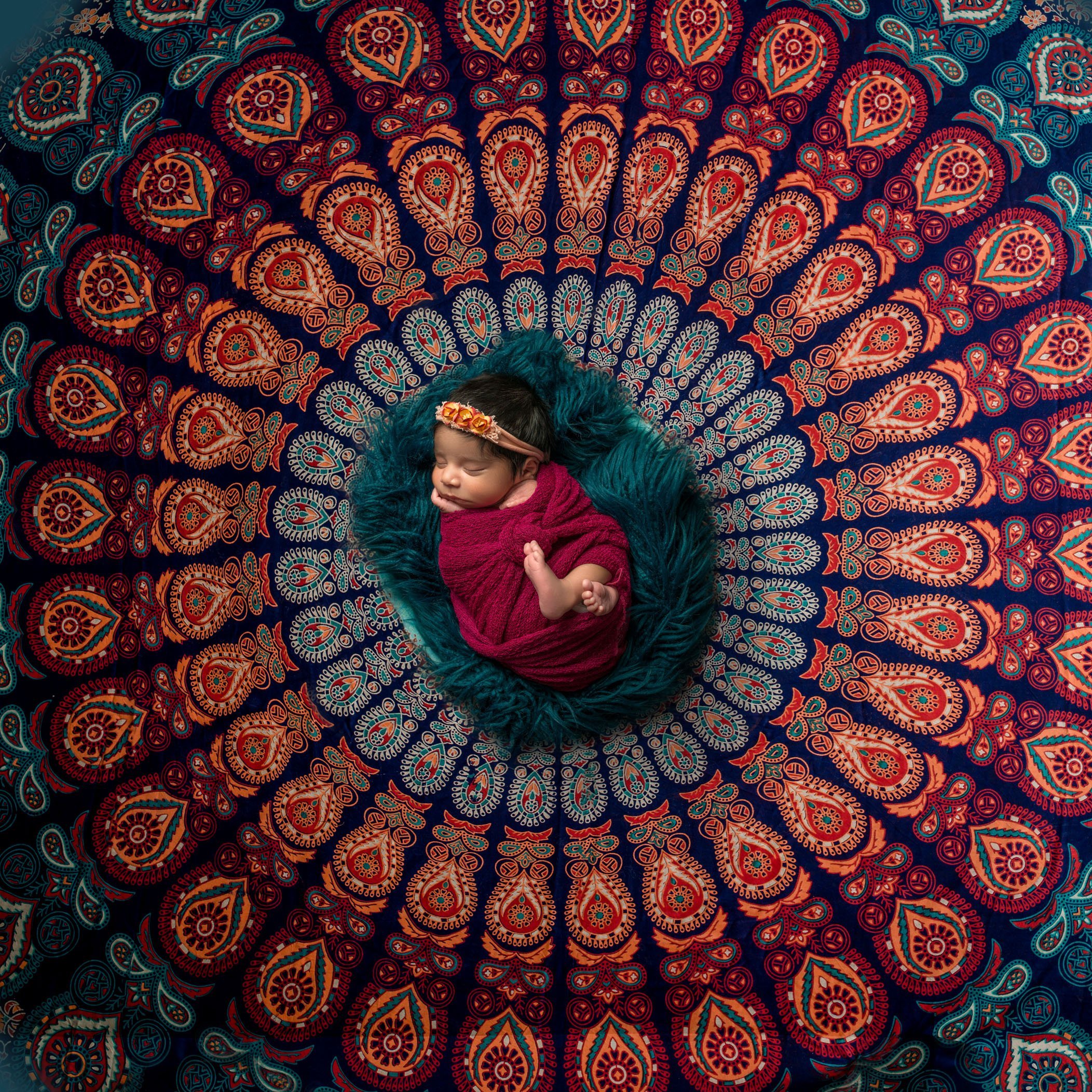 newborn baby sleeping in indian spiral tapestry