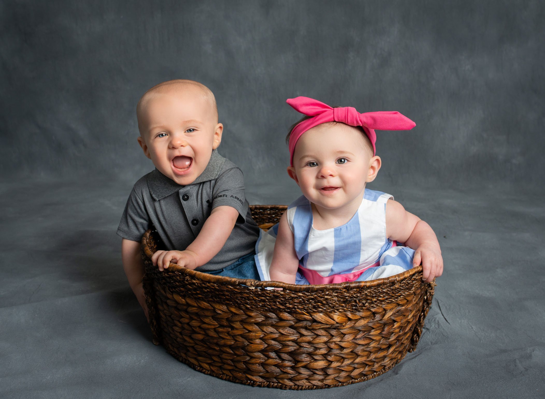 6 month old girl boy twins sitting in basket smiling at the camera