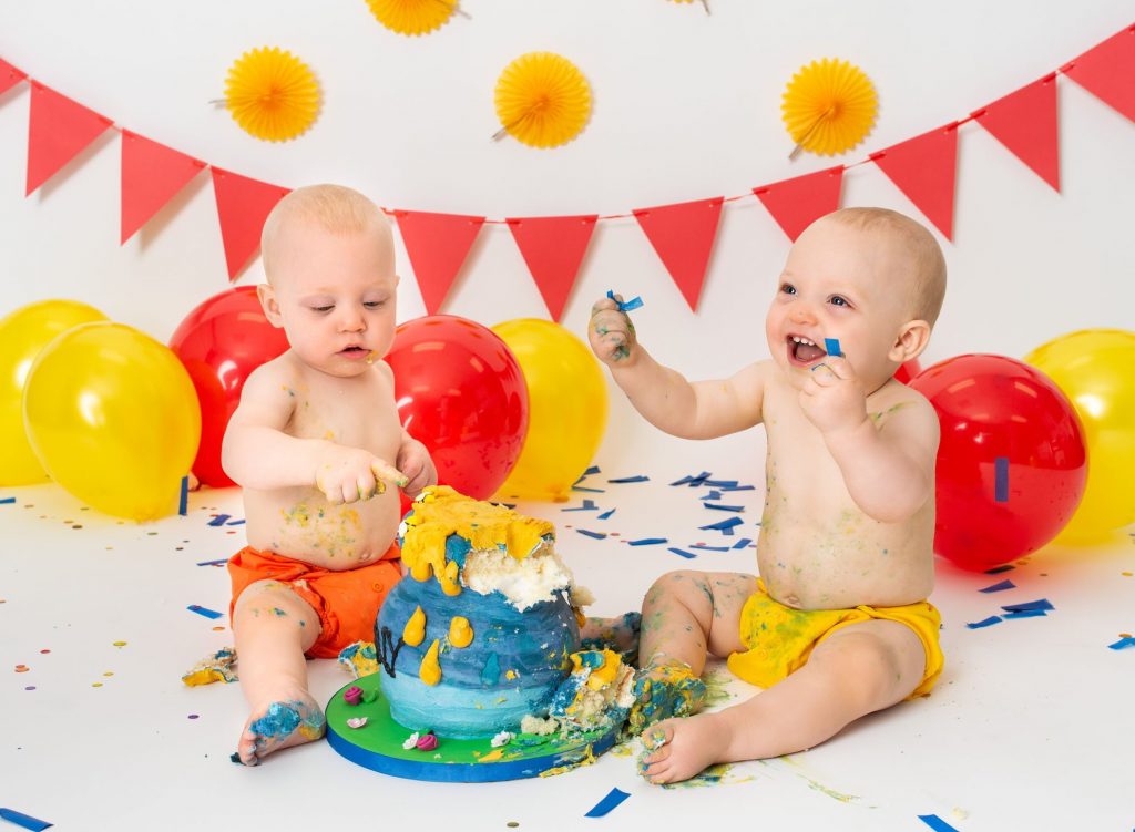 Twin 12 month old boys enjoying their smash cake