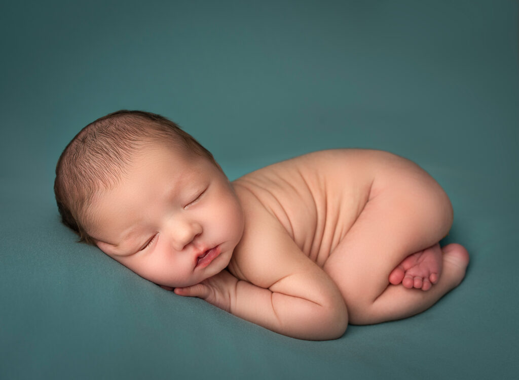 when is the best time for newborn photoshoot newborn baby sleeping on teal blanket