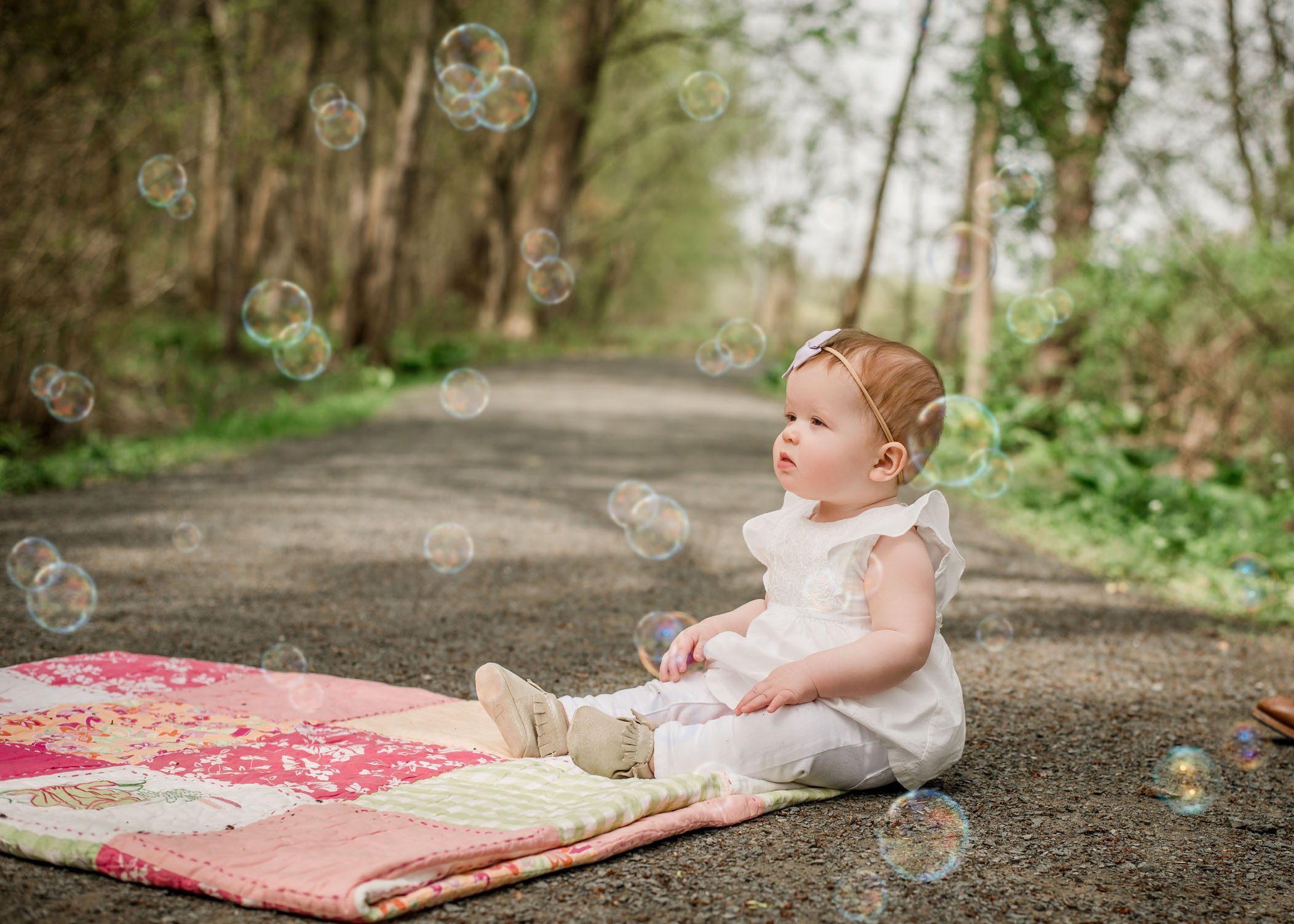 9 mo old baby girl looking at bubbles in the garden