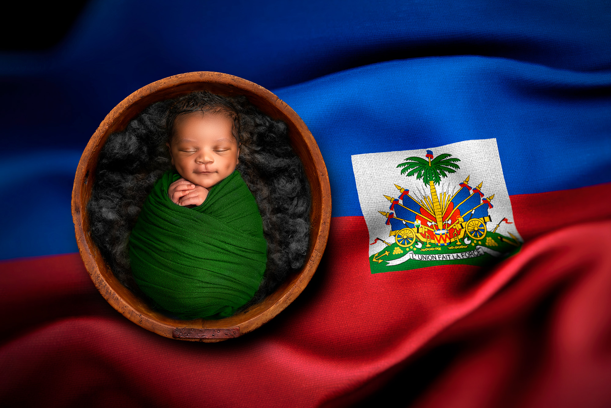 newborn photo studio newborn boy wrapped in the Haitian flag in a bowl