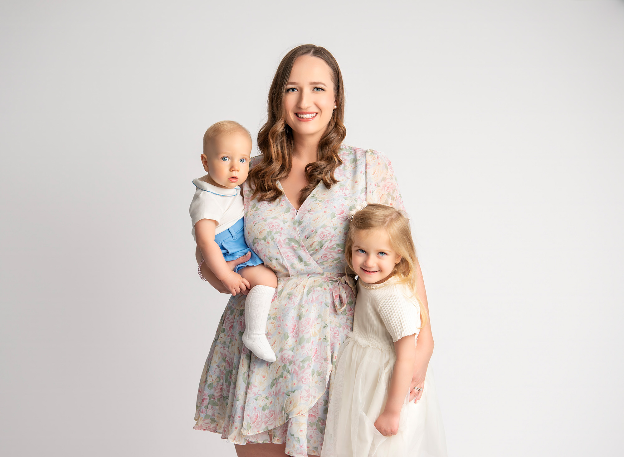 All White Baby Milestone Smash Photoshoot Mom with 2 kids on a white background