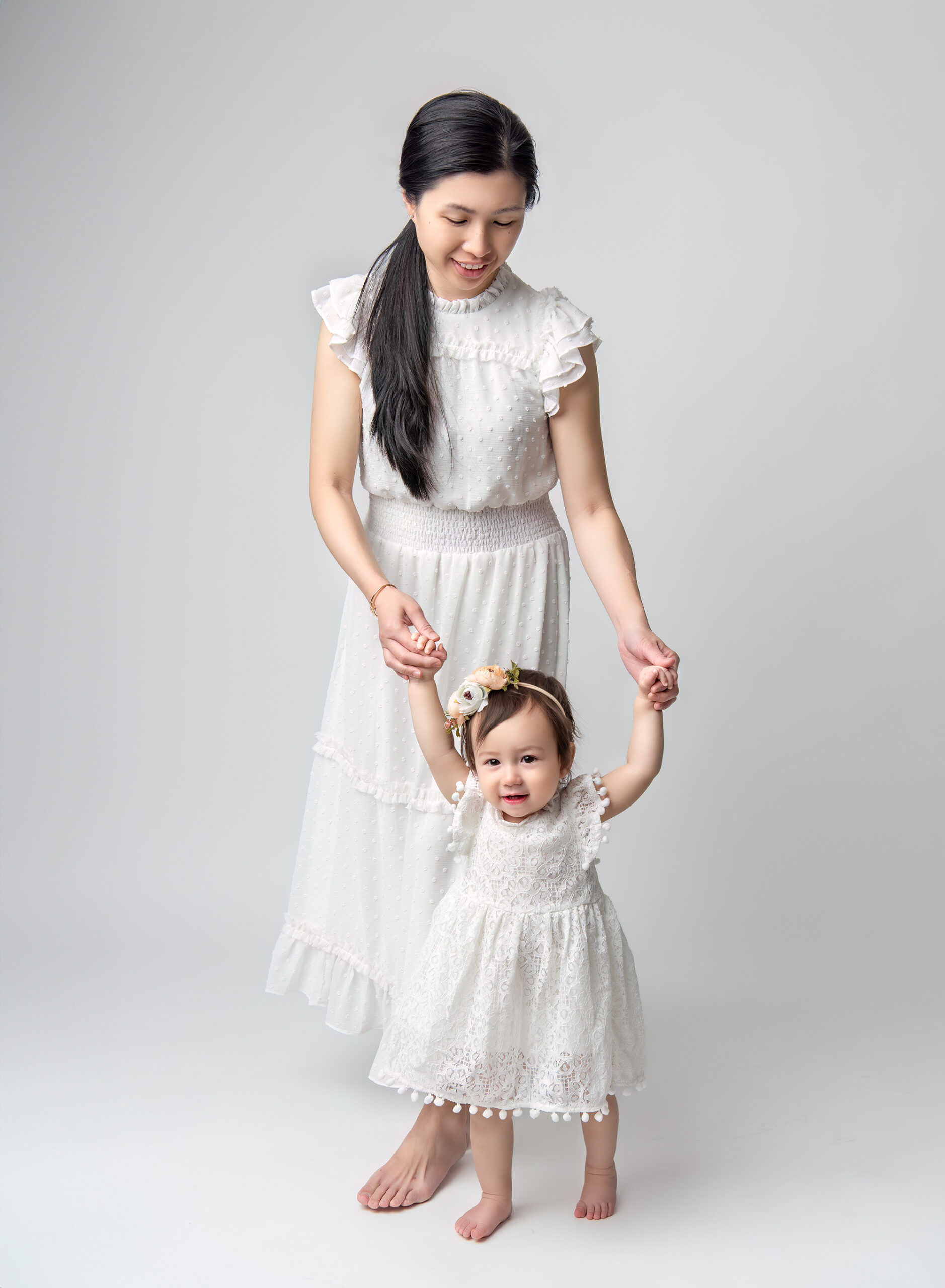 Mom holding Sophie’s hands, smiling down at her