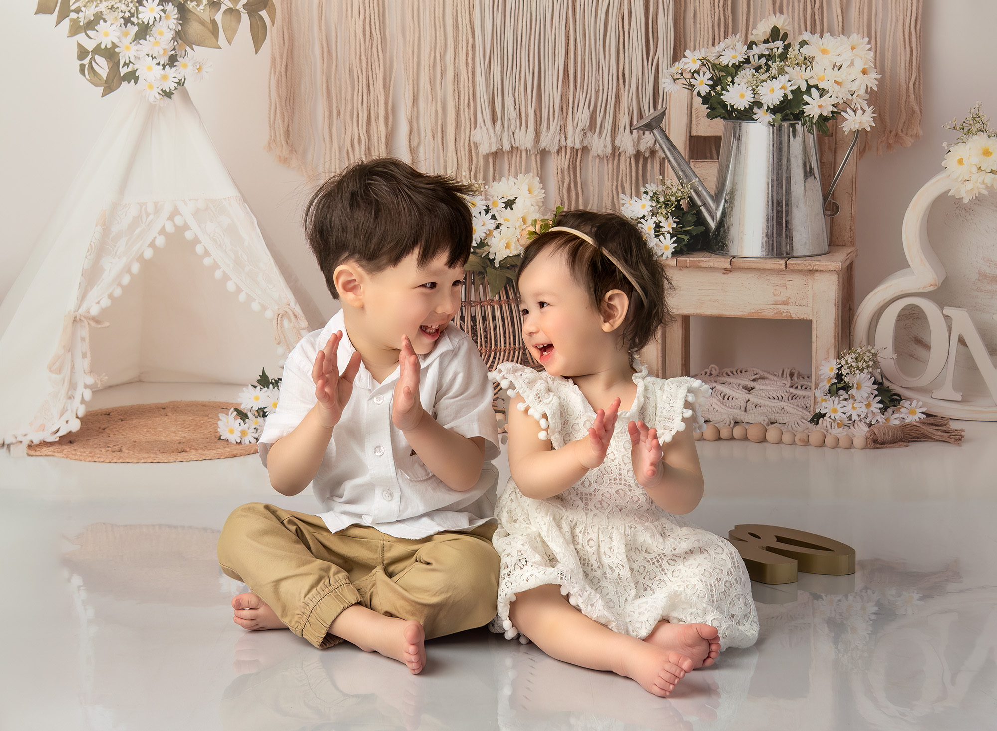 Sophie and Joshua clapping their hands and smiling at each other