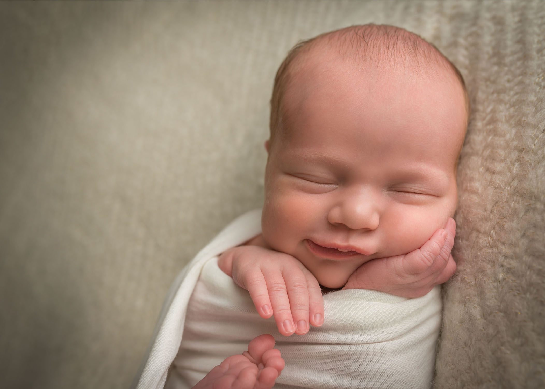 newborn baby girl smiling in her sleep