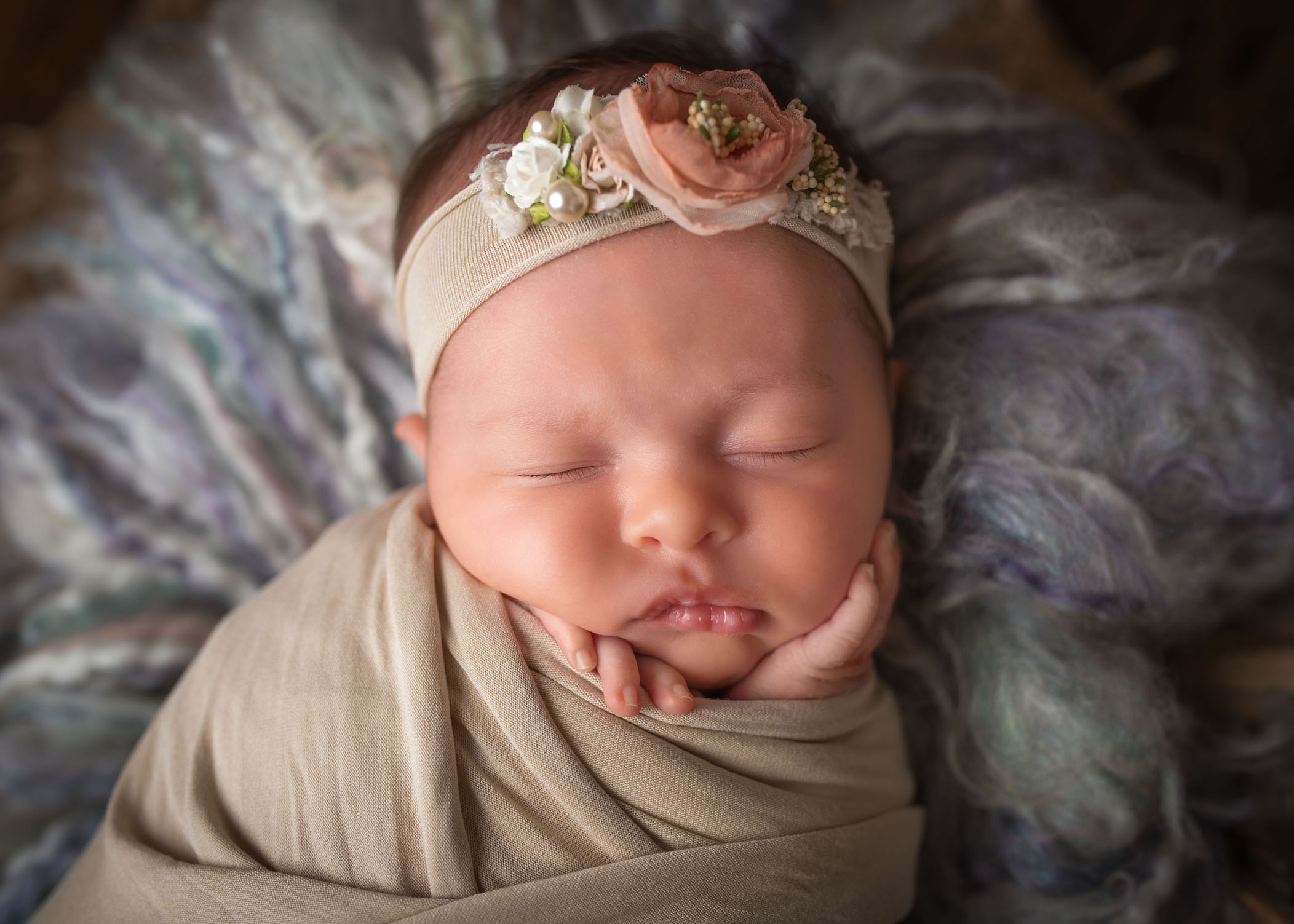 newborn baby girl asleep with hands on her face closeup