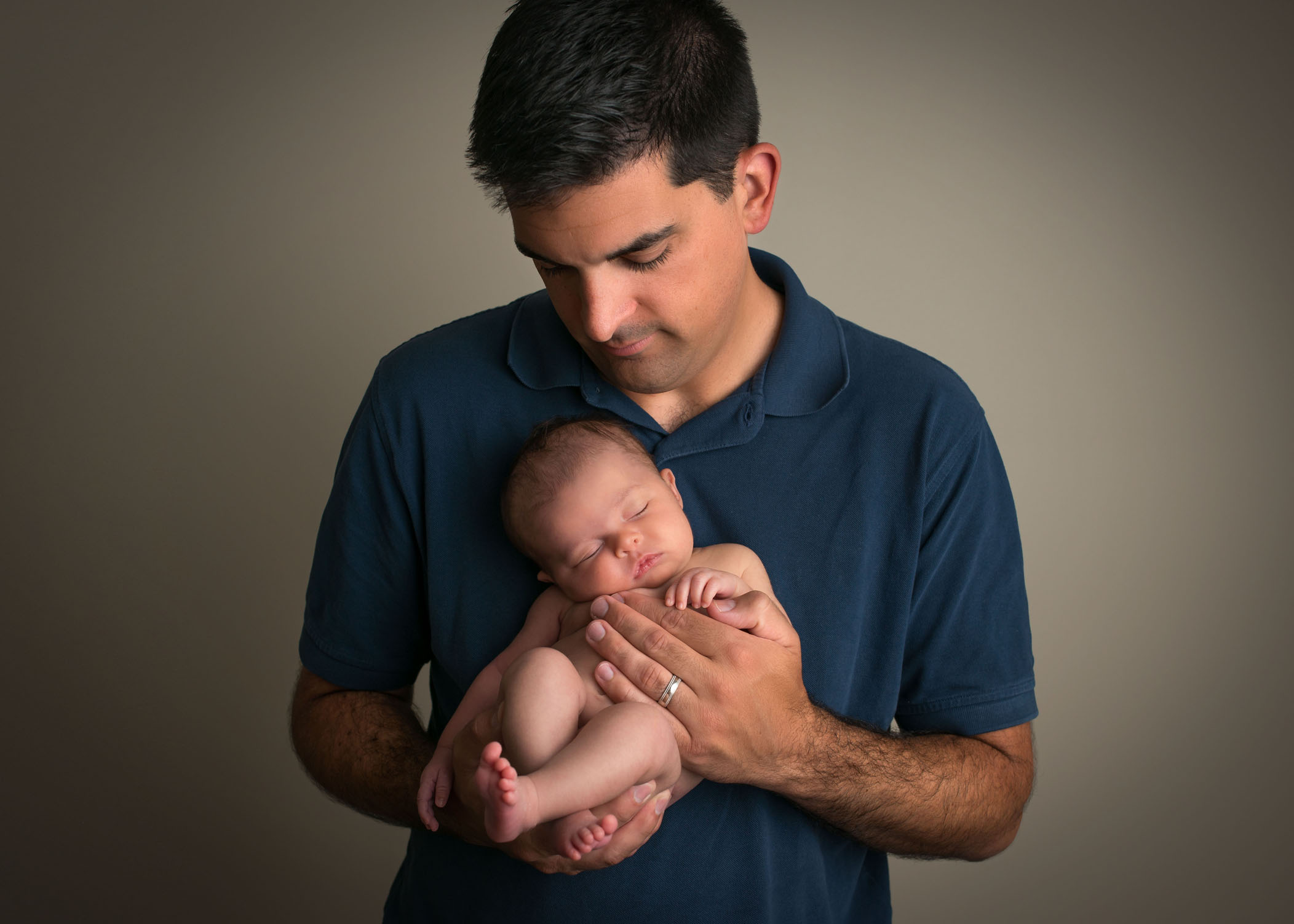 Dad holding his newborn daughter against his chest