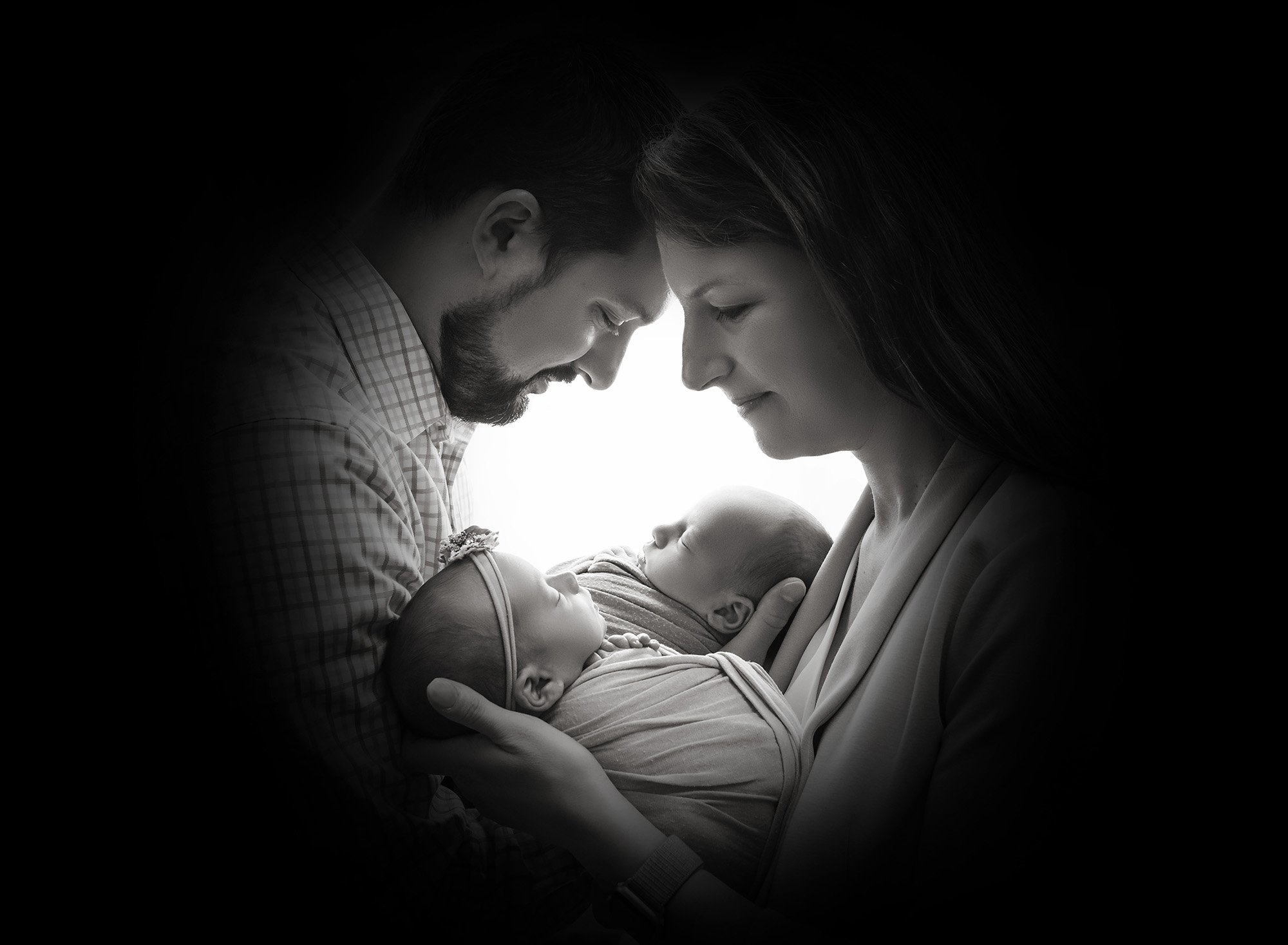 Twins newborn photography silhouette shadow of new parents face's while cradling their newborn baby boy and girl